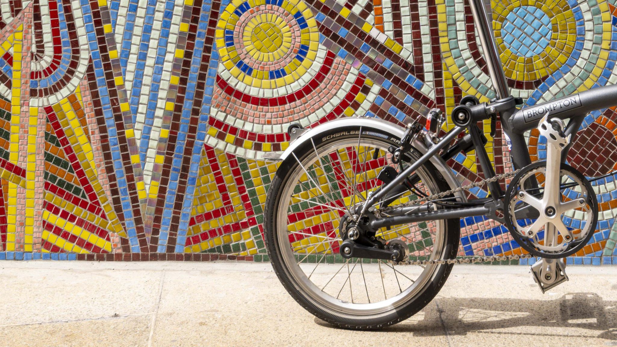 A bicycle in front of the mosaic mural