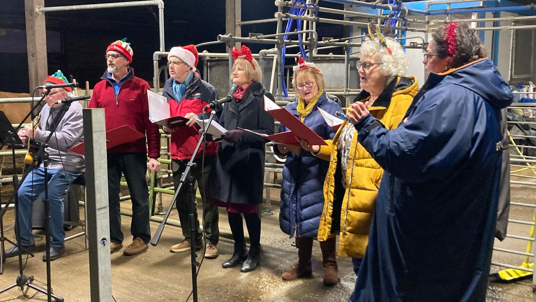 A group of people singing Christmas songs on a Norfolk farm