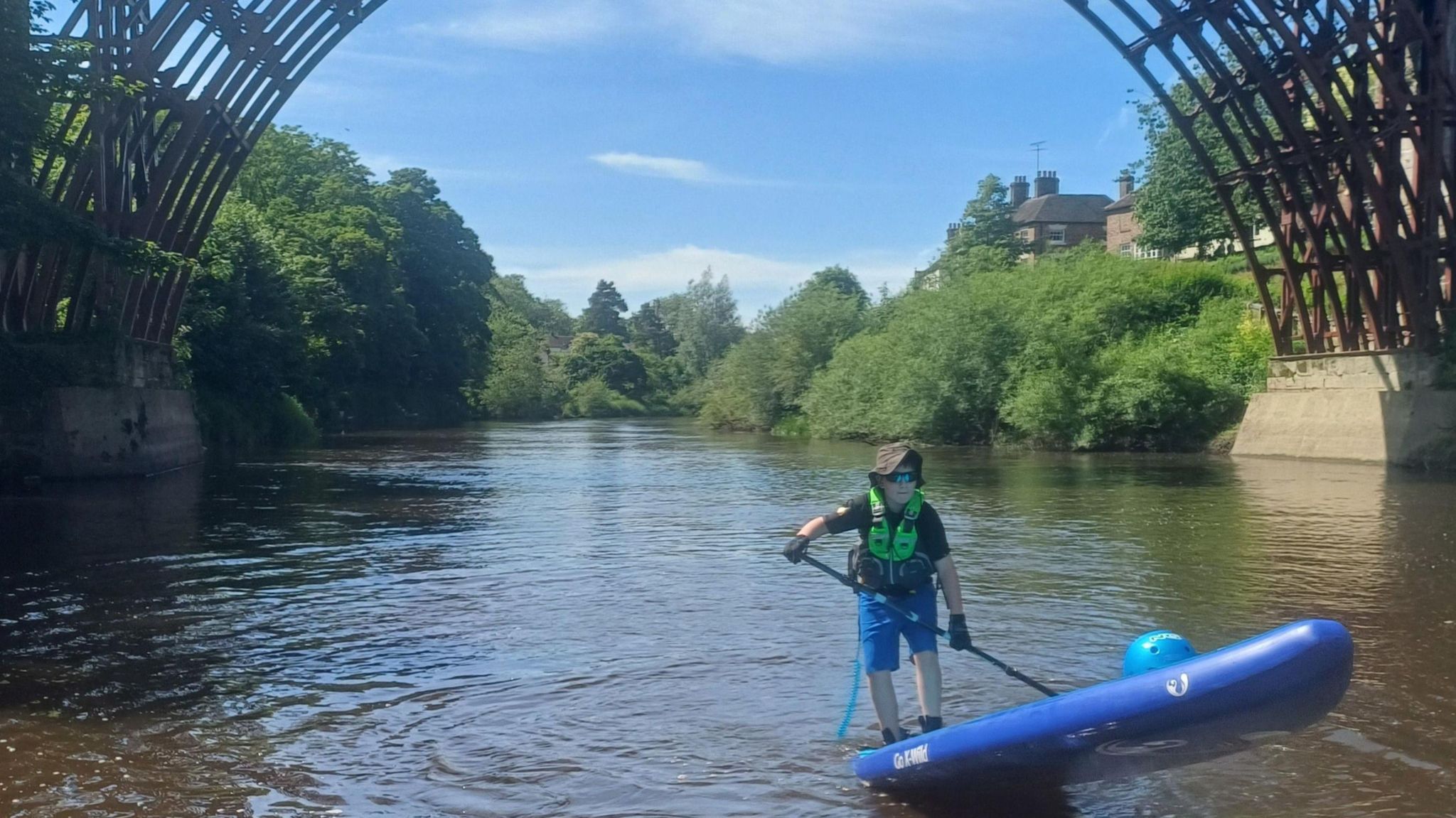 Len, 11, on a paddleboard in a river