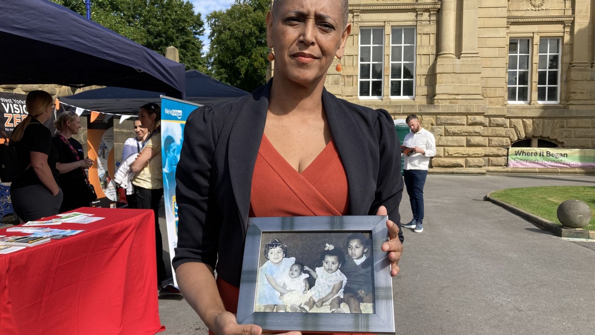 Alison Lowe holding a framed photos of her family