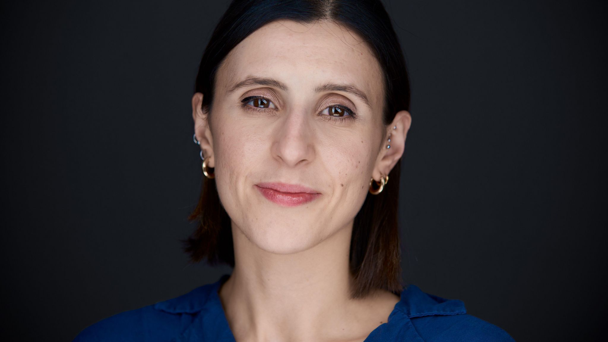 A woman with short brown hair smiles at the camera