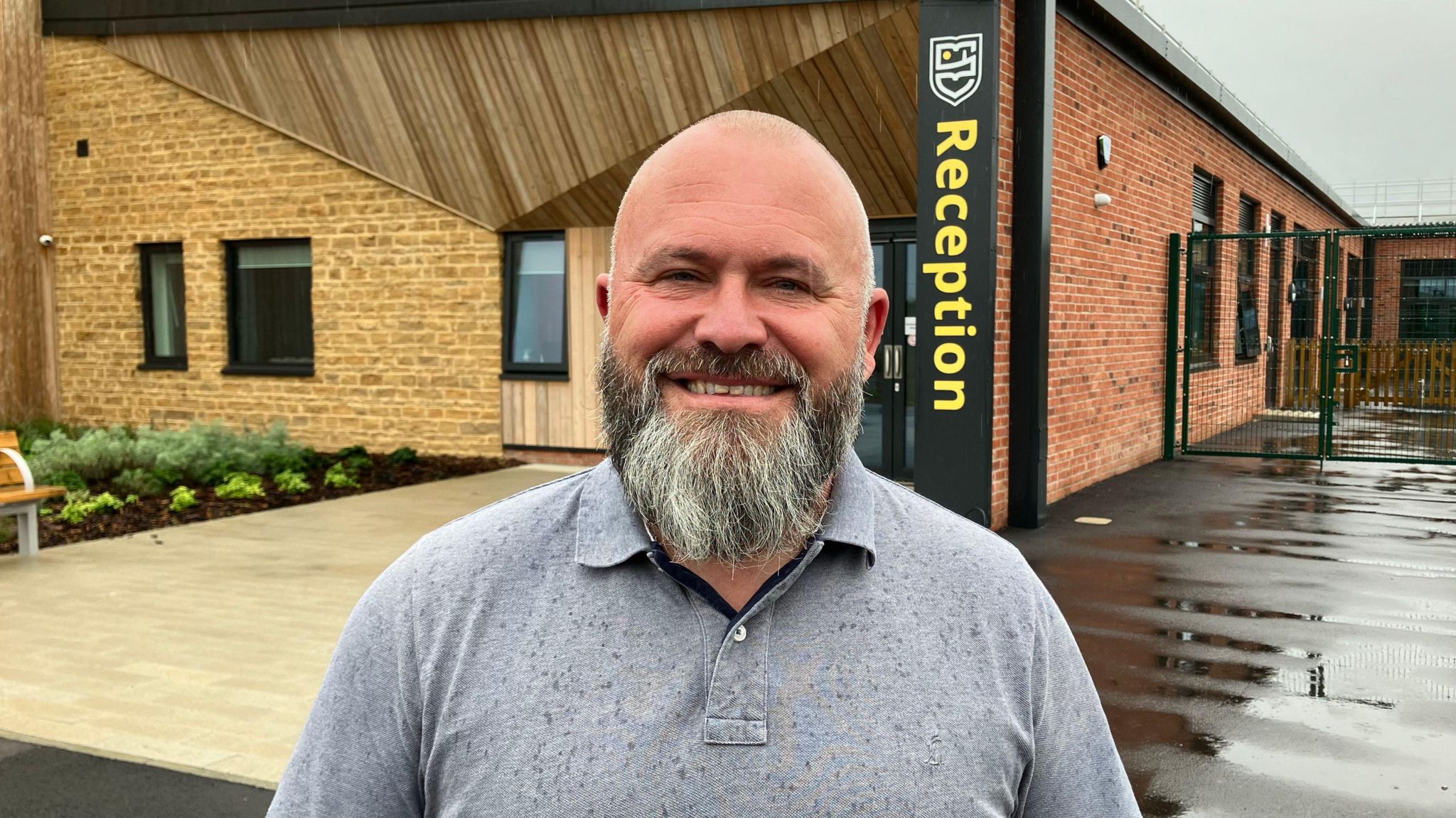 Head Stu Lambert at Hill View School smiling at the camera outside the main school door