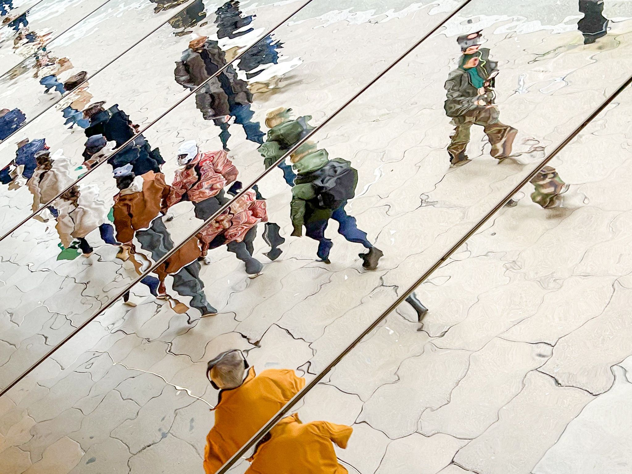 People reflected in rippled mirrors