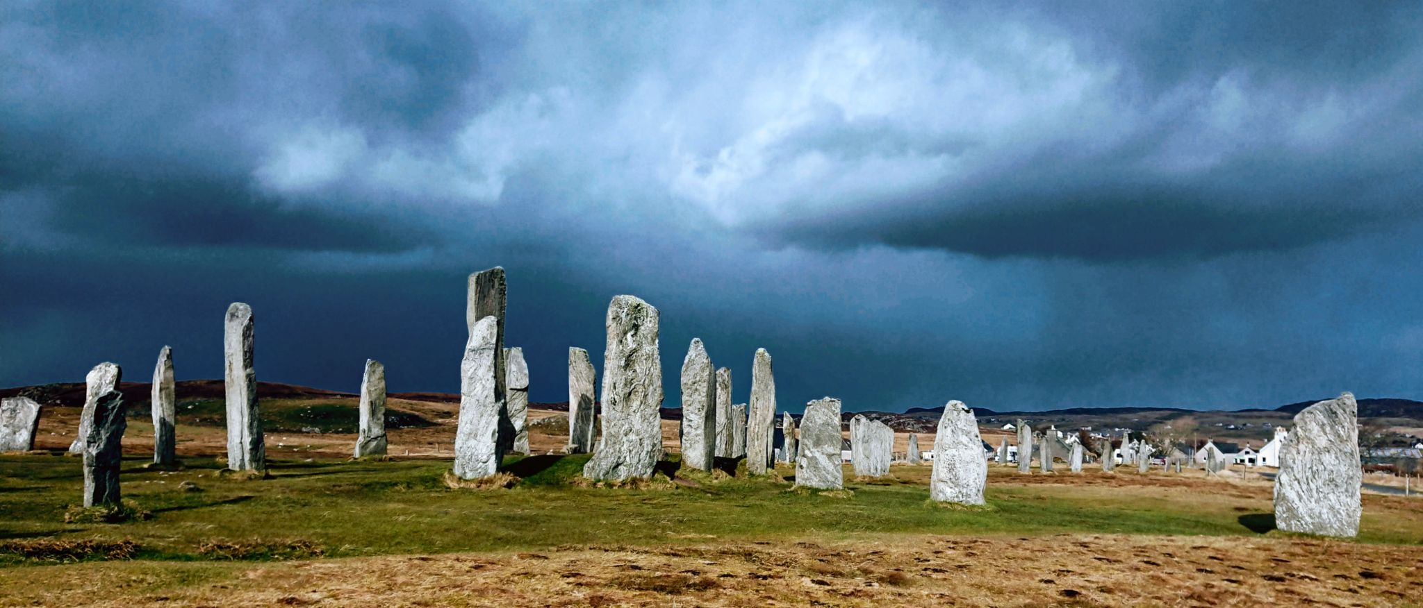 Calanais stones below a dark and stormy blue/grey sky