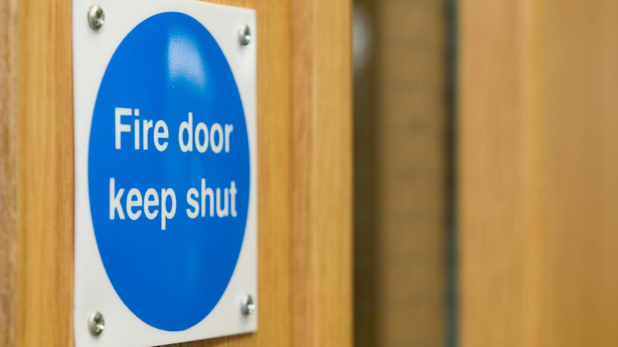 A fire door sign, screwed into a fire door