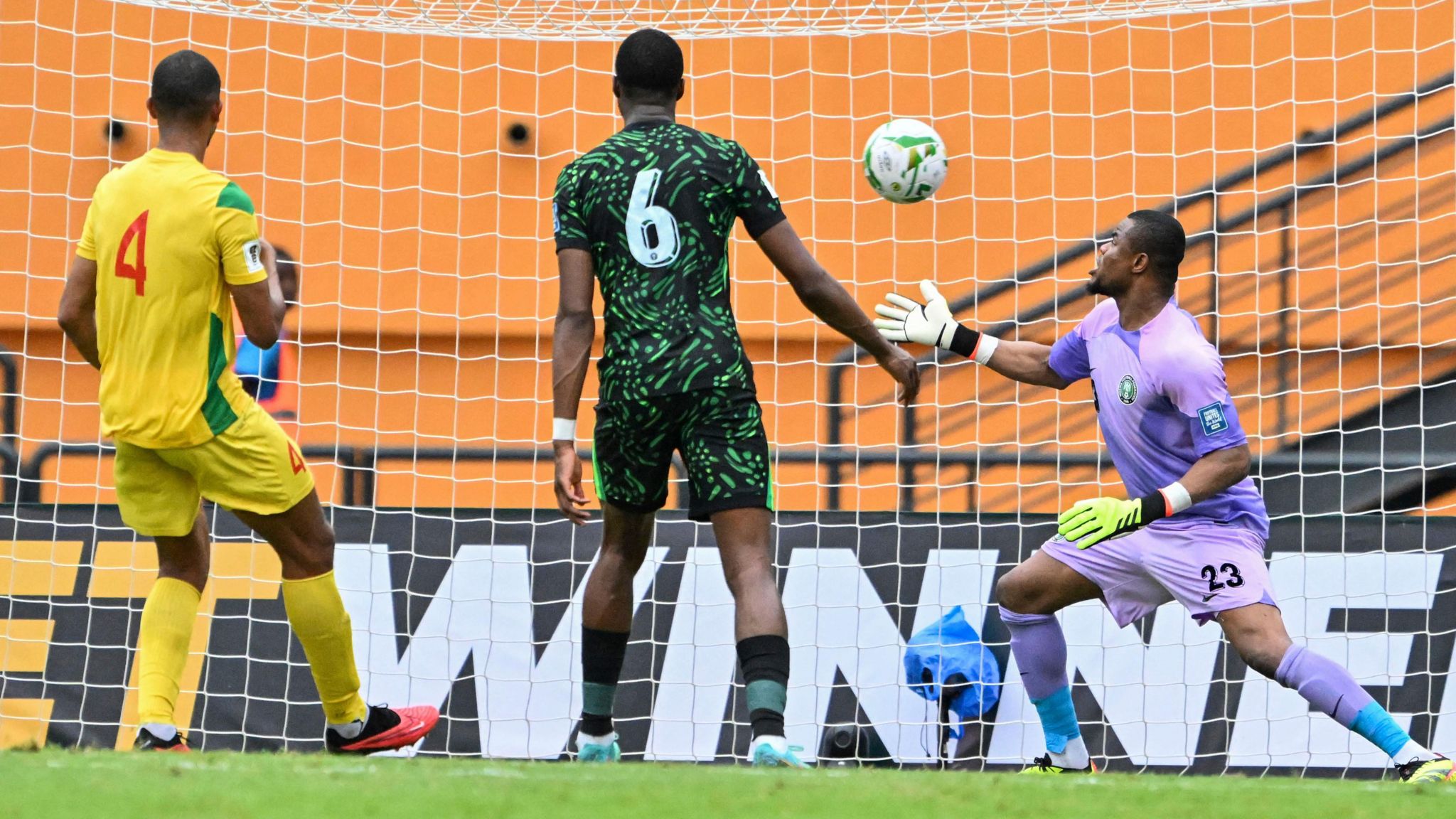 Nigeria goalkeeper Stanley Nwabali, wearing a purple kit, reacts in shock as the ball goes into his net during a game against Benin