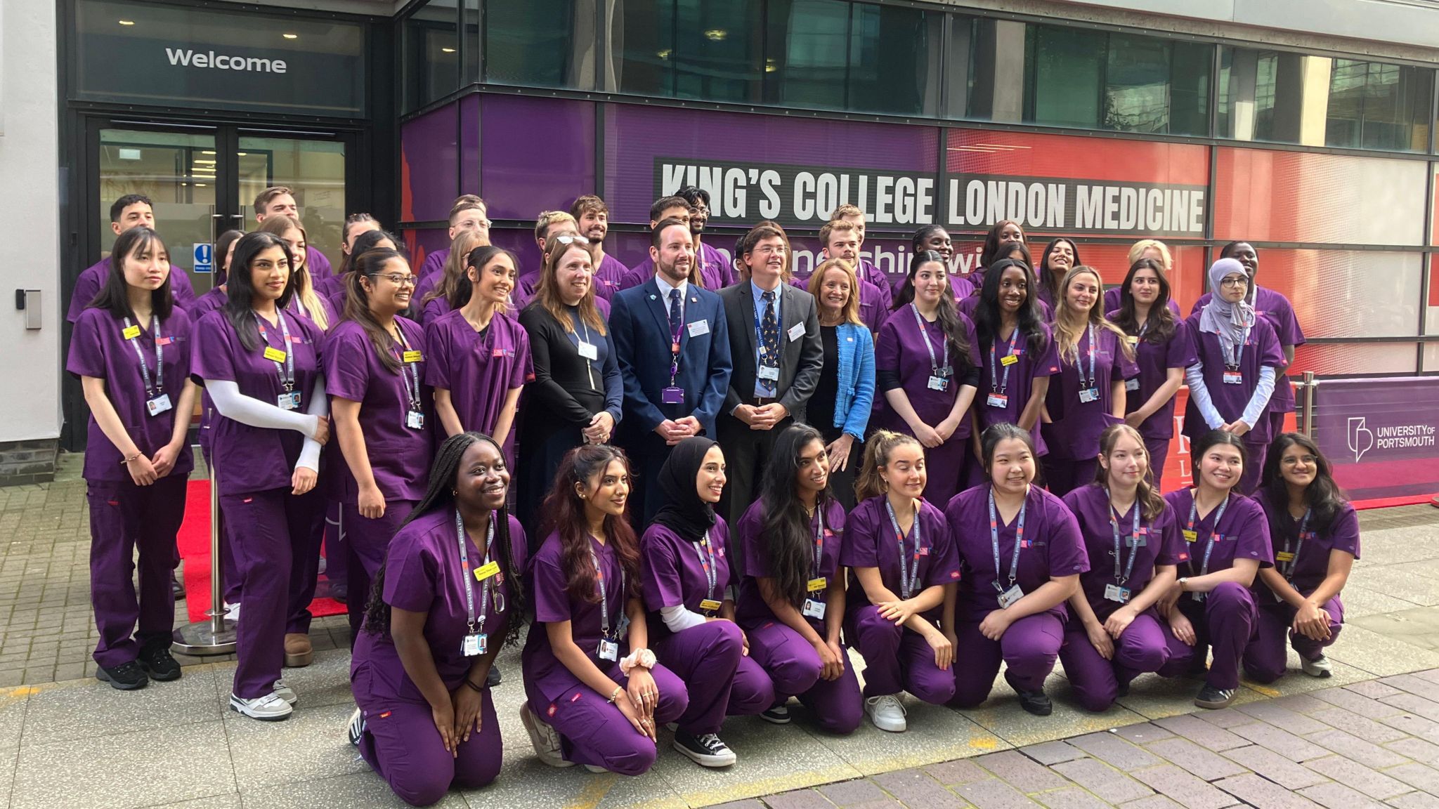 Group photo of medical students in purple medical clothing