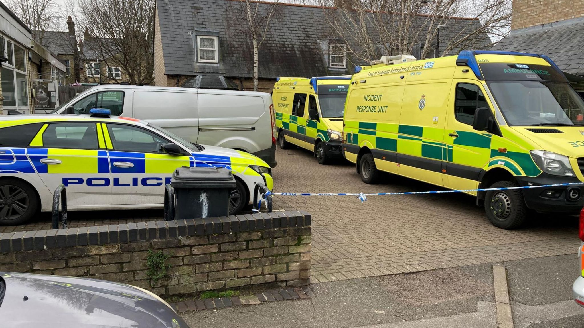 Two ambulances and one police car have been parked behind police tape