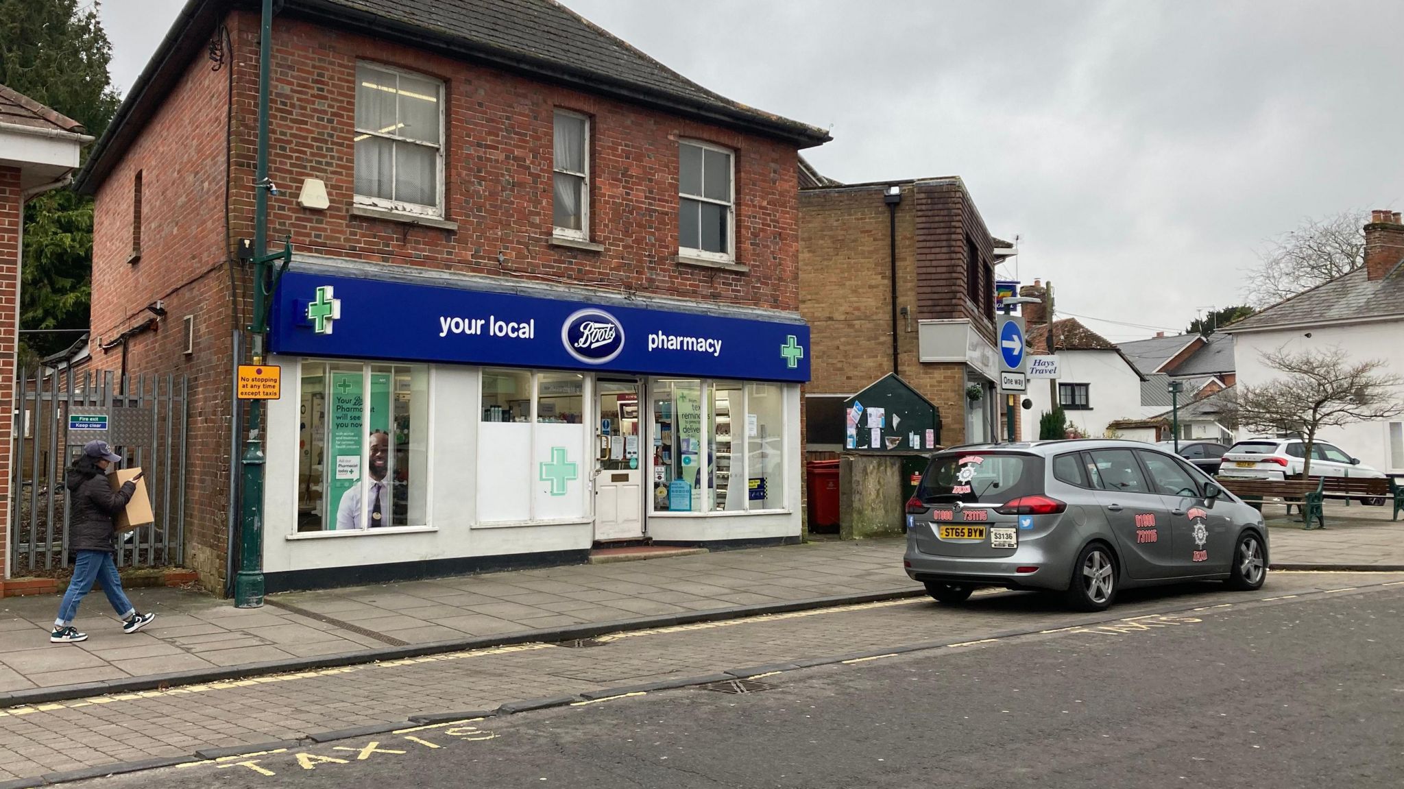 A small boots pharmacy in a red brick building. 