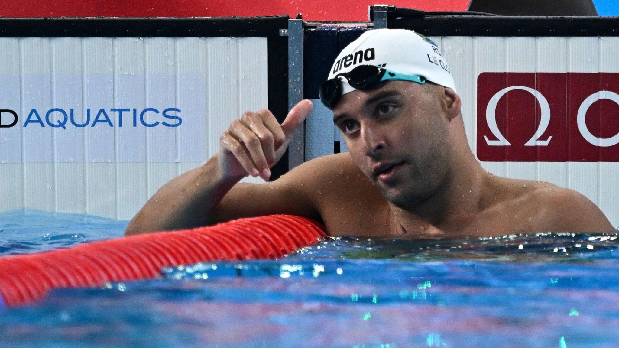 Chad le Clos makes a thumbs up gesture while resting on a lane divider in a pool