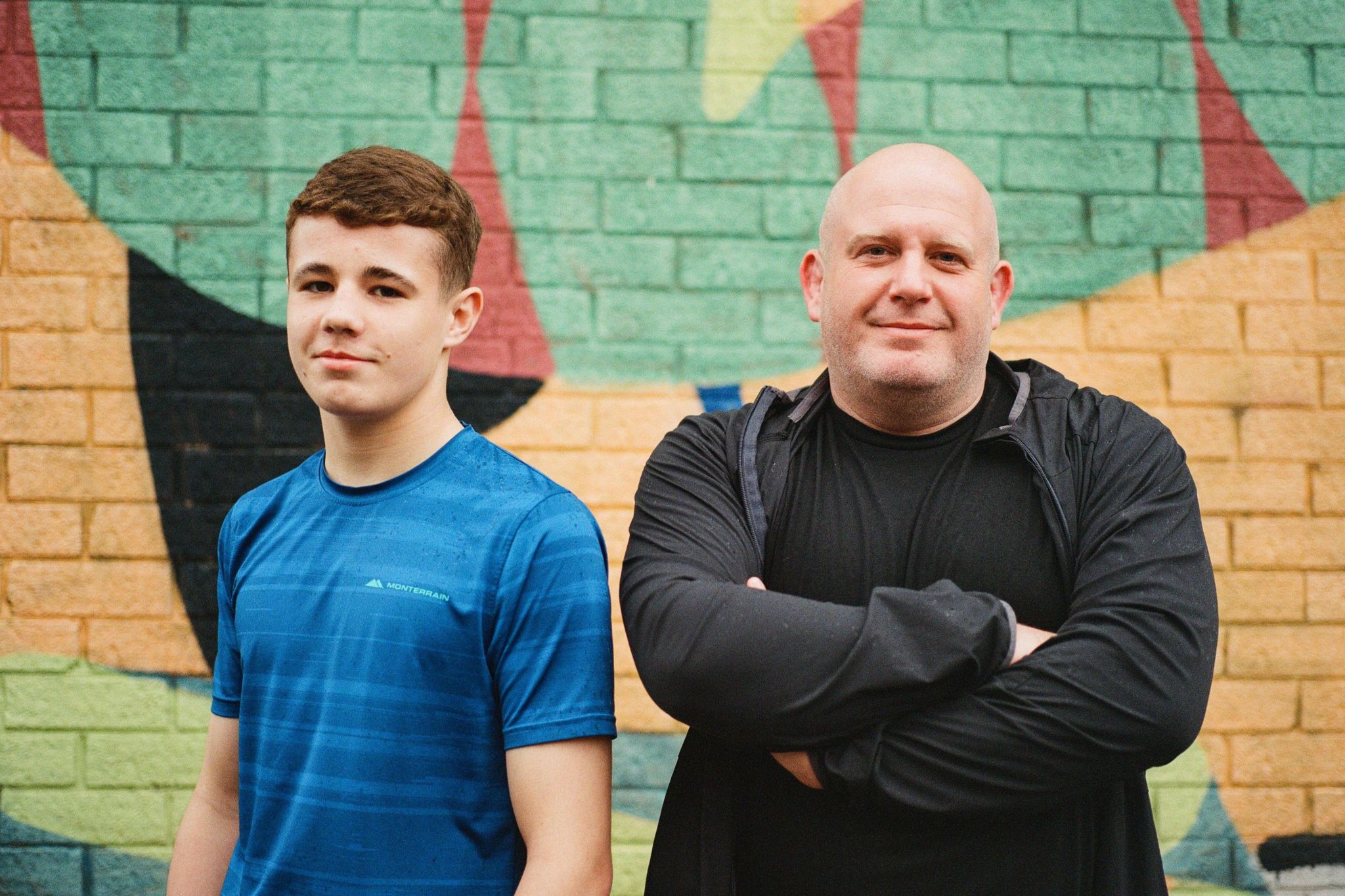 Jack Rimmer and his father Paul pose for a picture in front of an abstract mural