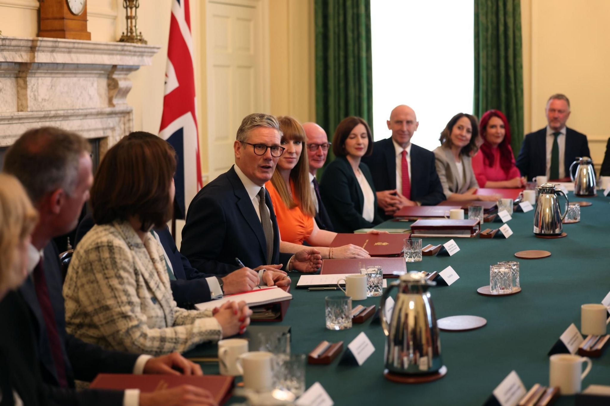 Keir Starmer addresses the cabinet in the Cabinet Room of No 10. They are sat around the iconic table, with papers, files and glasses of water laid out. Mr Starmer is sat next to Deputy PM Angela Raynor and Cabinet Secretary Simon Case