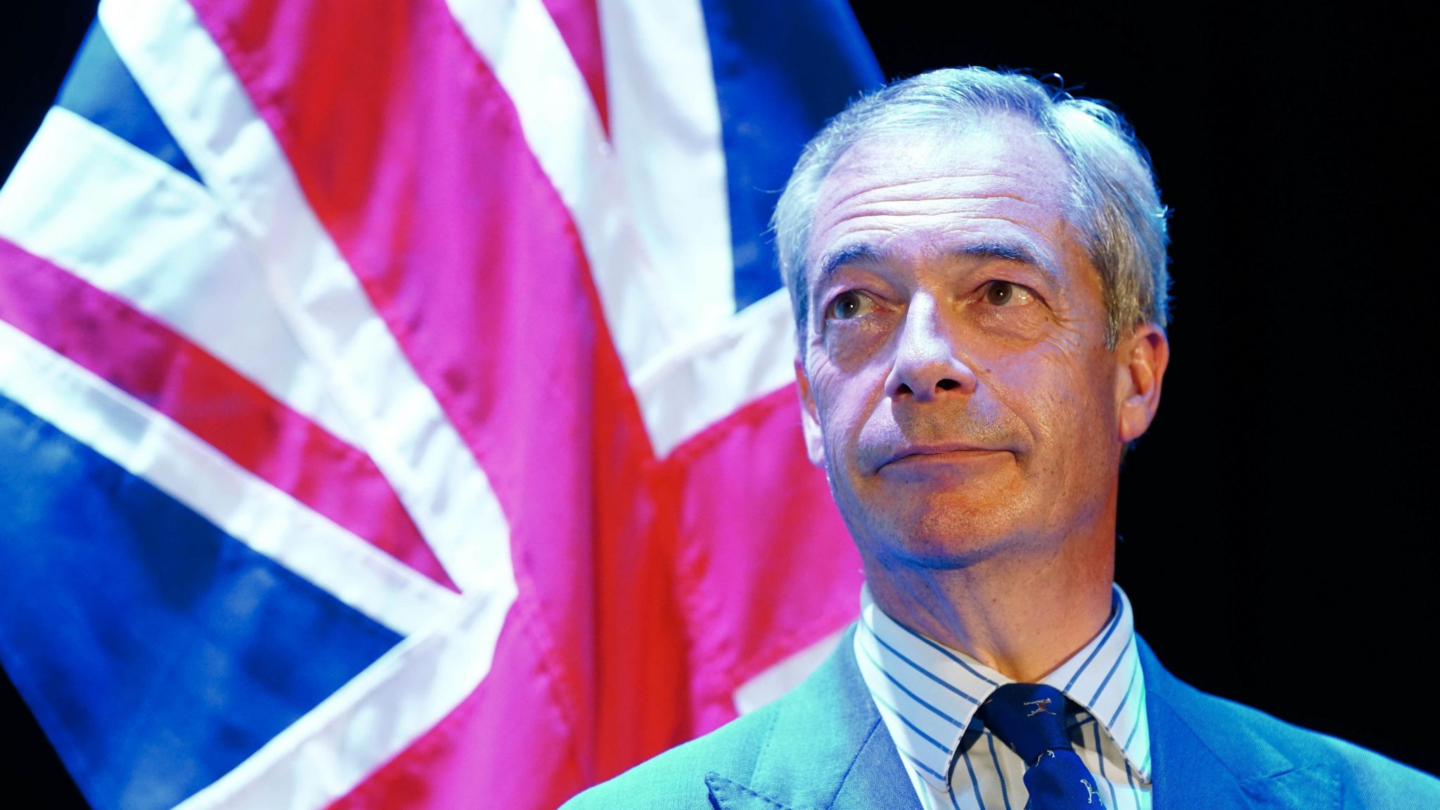Nigel Farage with the UK flag behind him