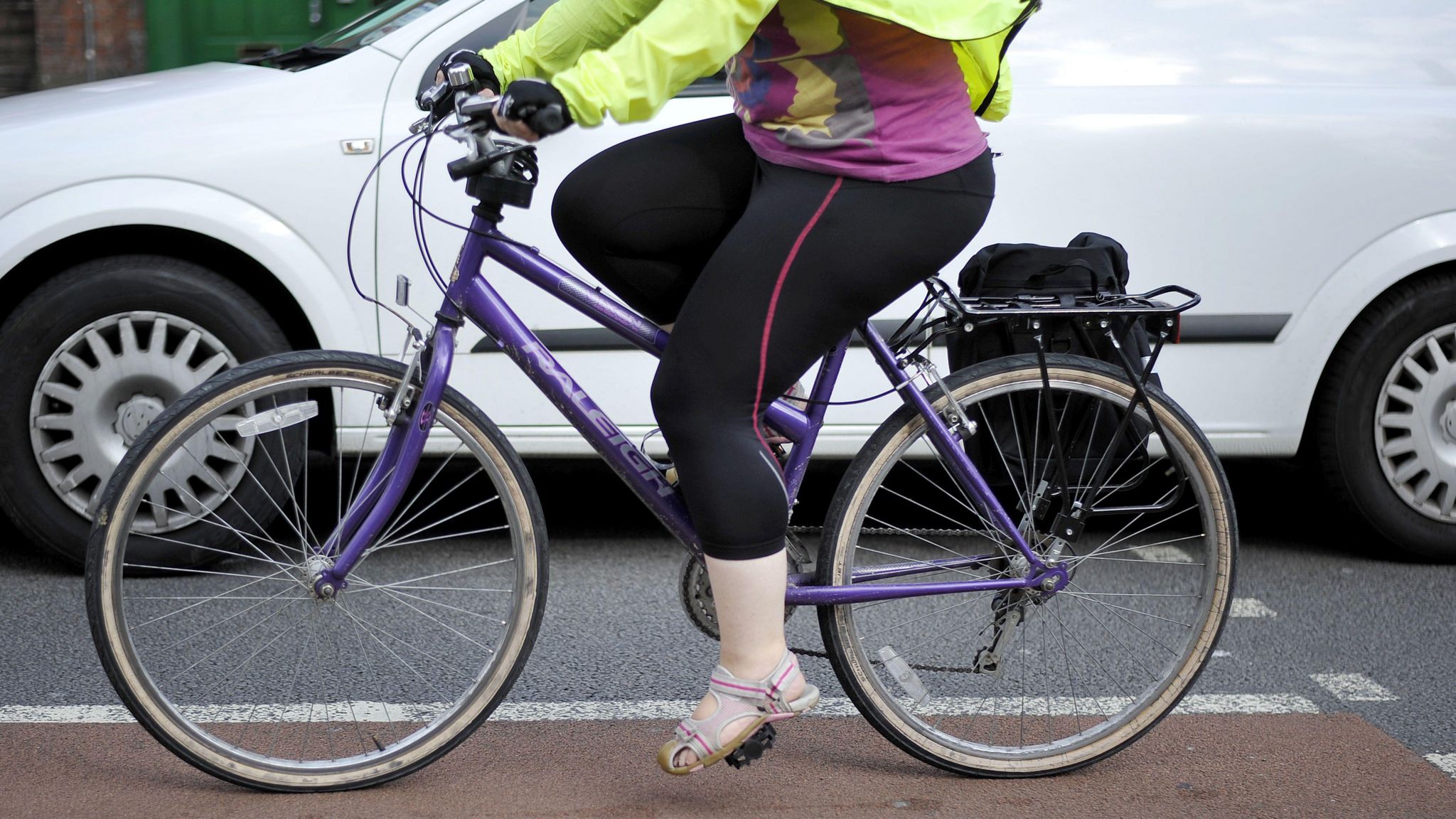 A person riding a bicycle on the road in the middle of traffic in Bristol