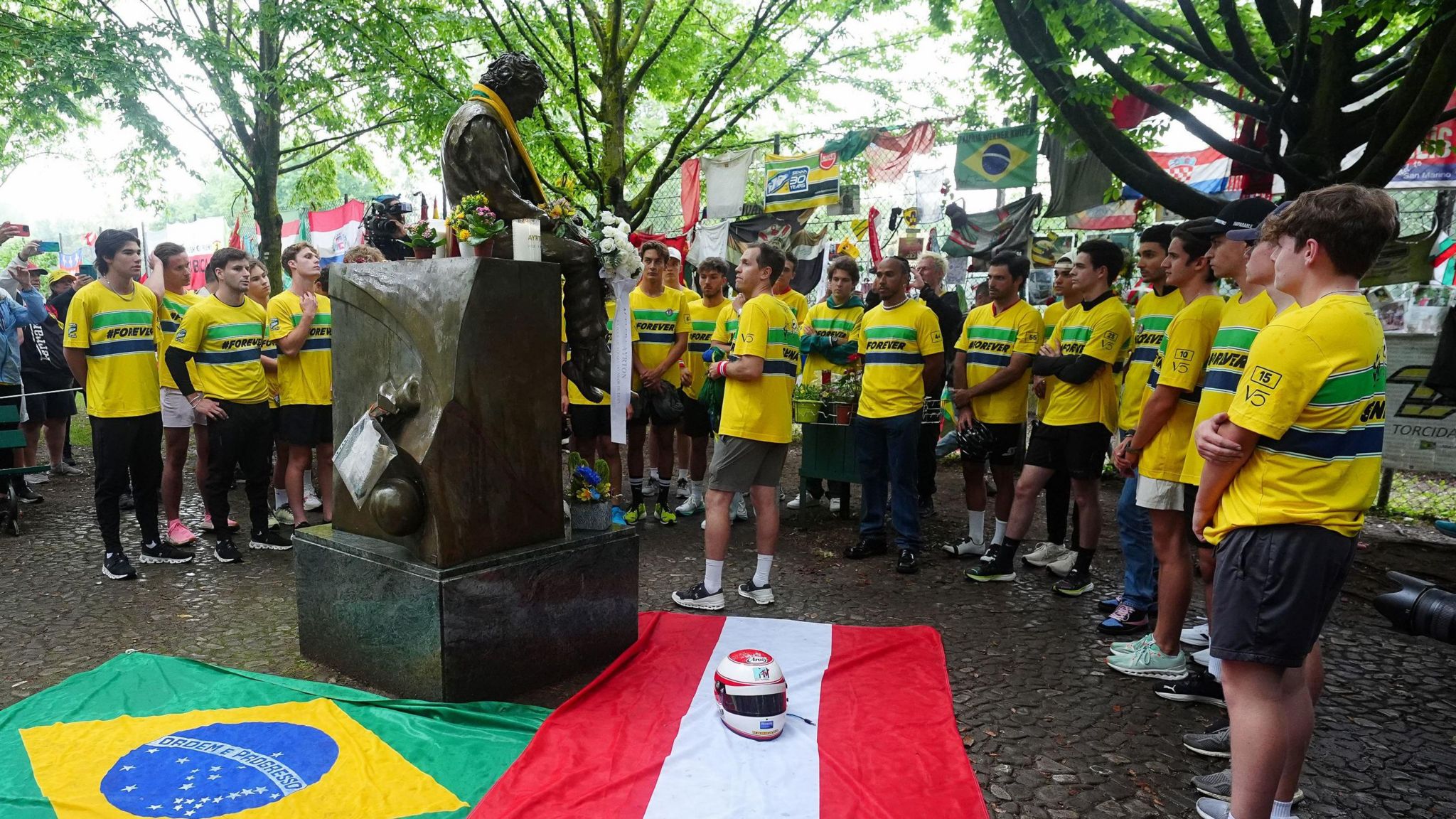 F1 drivers gathering round the Ayrton Senna statue at Imola