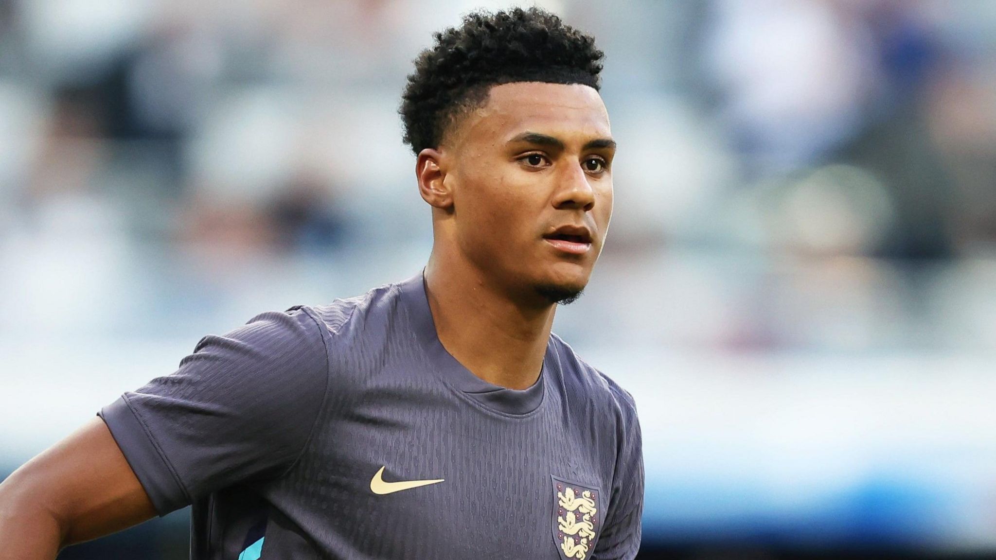 A close up of Ollie Watkins, wearing England's changed dark blue kit against Bosnia on Monday