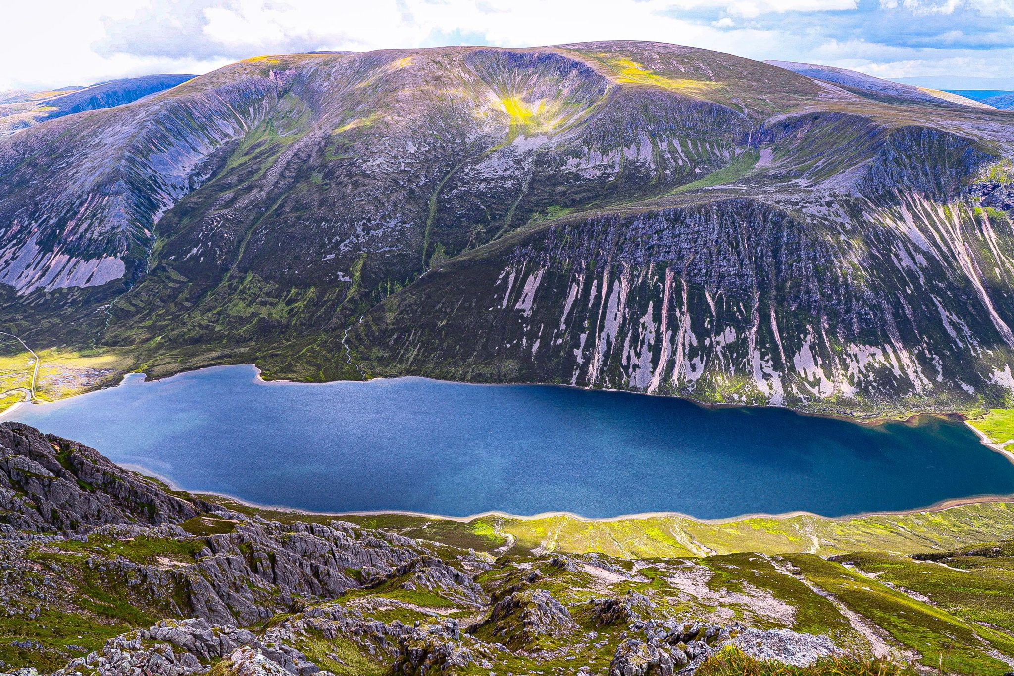 A loch wedged between two large hills, image taken from the peak of one of the hills looking down