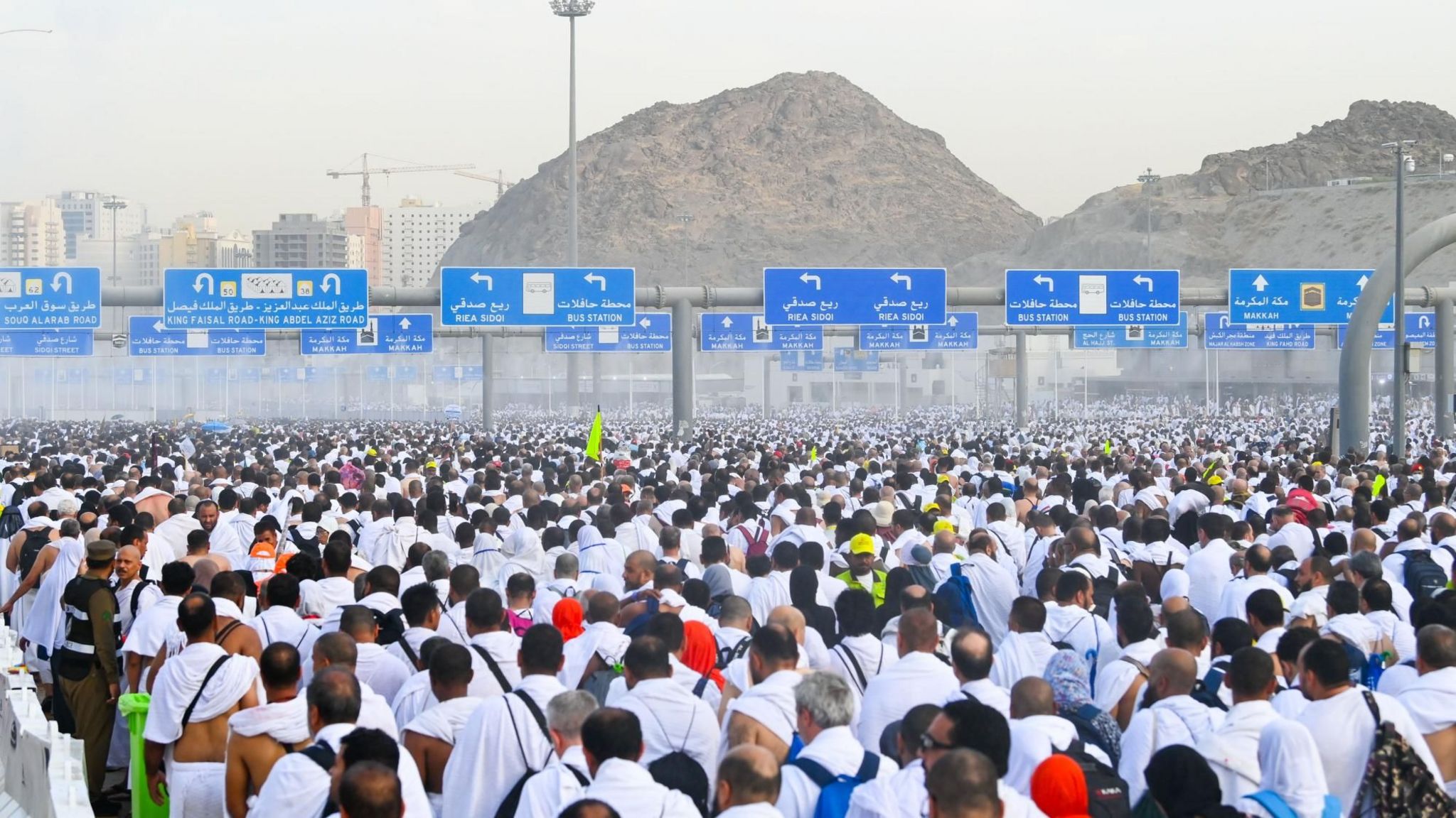 Crowd of pilgrims in white clothing on a road near Mecca