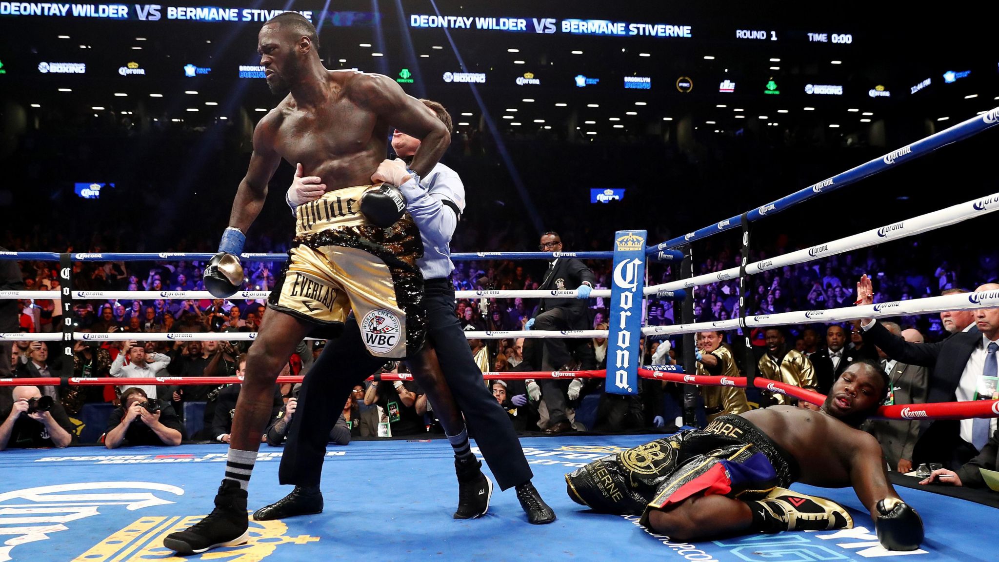 Deontay Wilder is led away from a stricken Bermane Stiverne 
