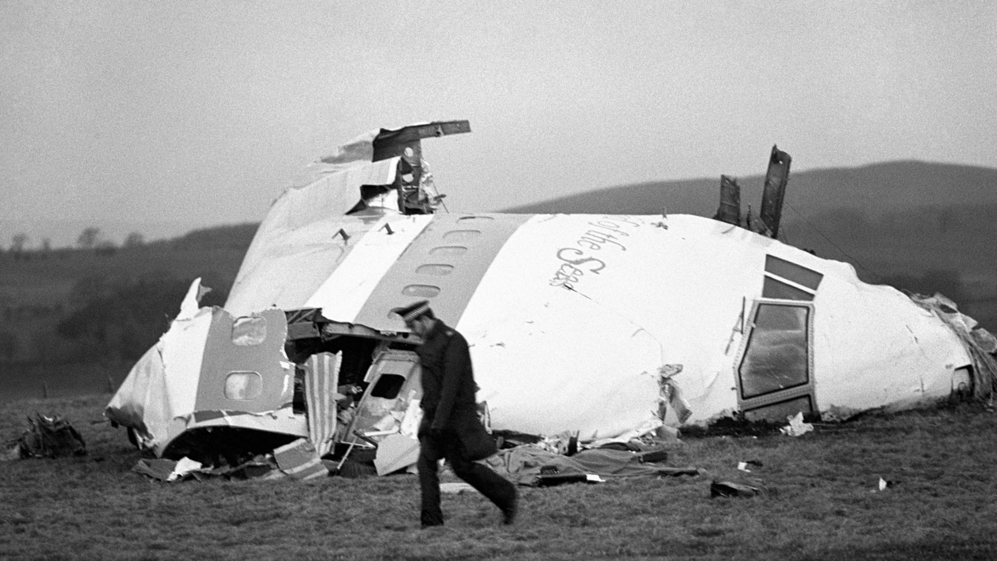 A police officer walks past the wrecked nose section of Pan Am flight 103 in a field at Lockerbie, December 22nd 1988, after the plane was blown apart by a terrorist bomb