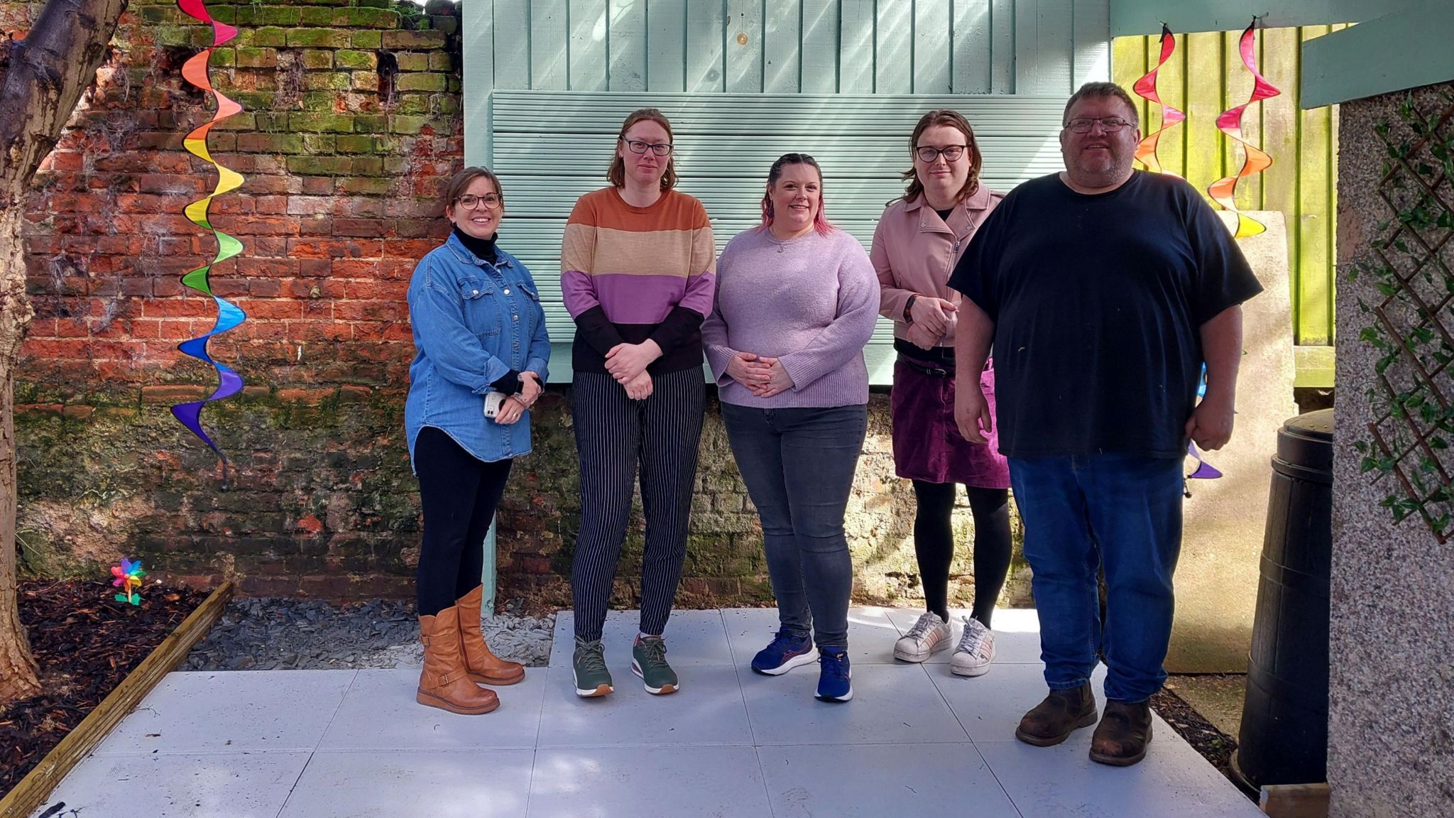 A group of people standing in a outdoor space that has been recently updated