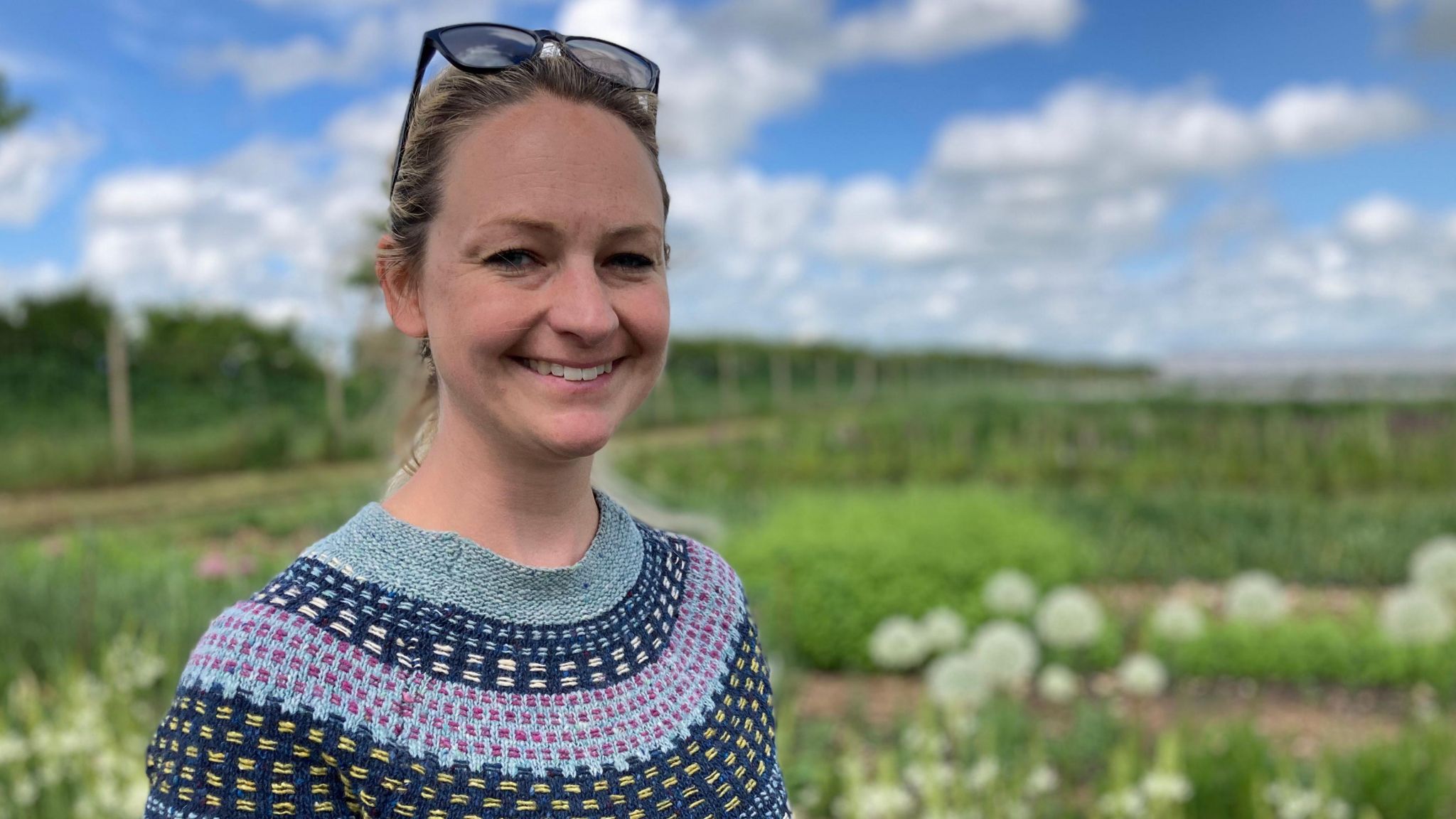 Grower Katie Stone in a field of flowers, which is in soft focus