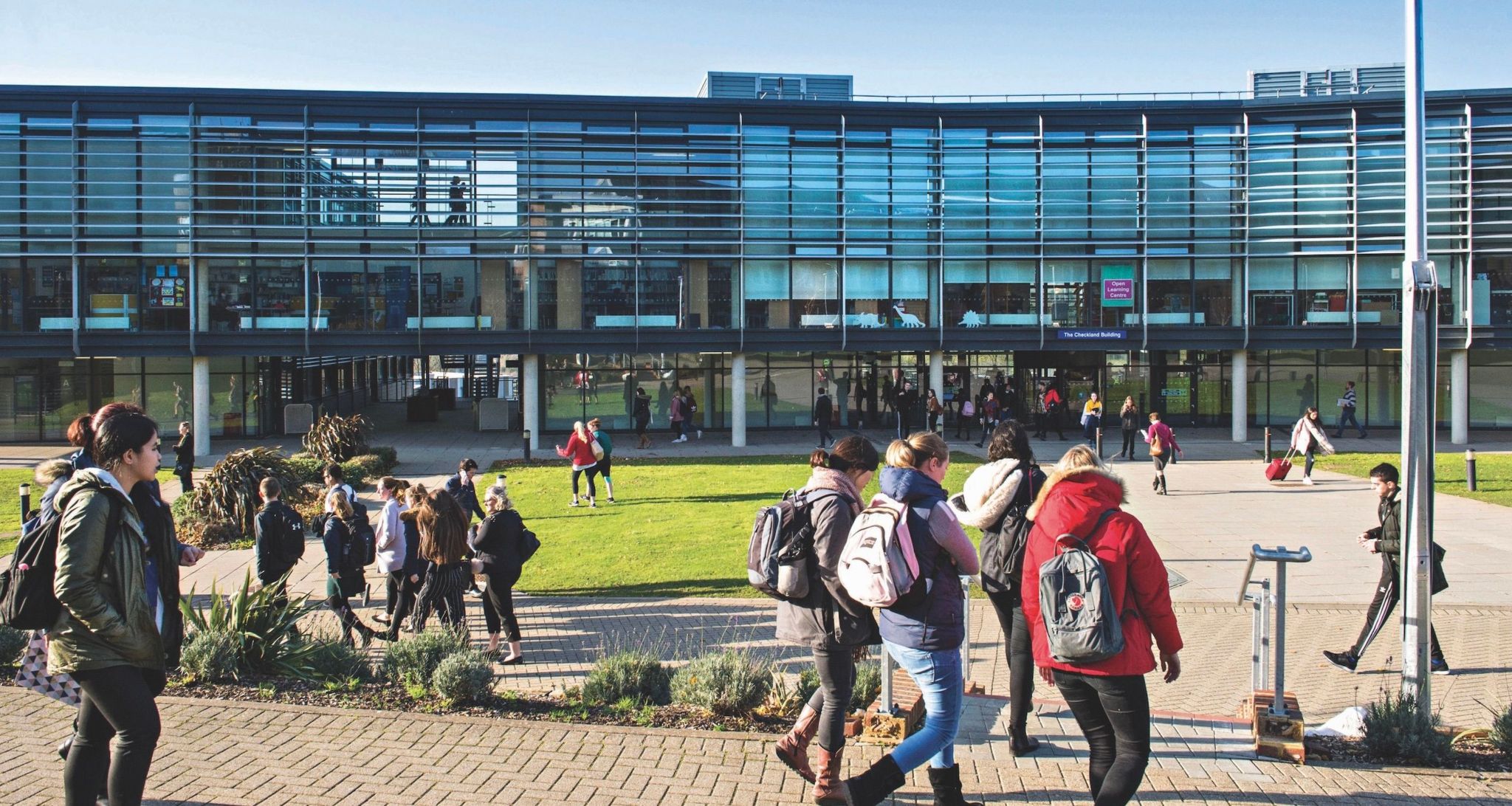 Falmer campus at the University of Brighton. Students walking outside of the building