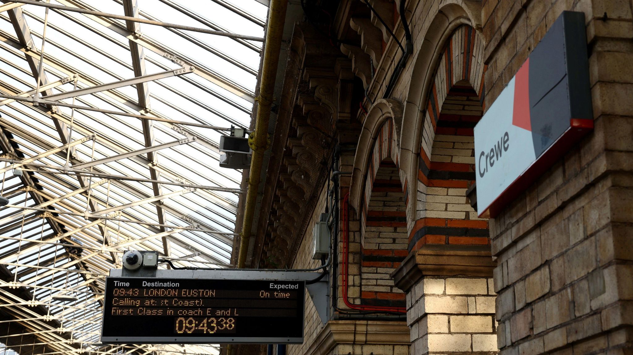 An information board and a sign that says Crewe at Crewe Station in Cheshire