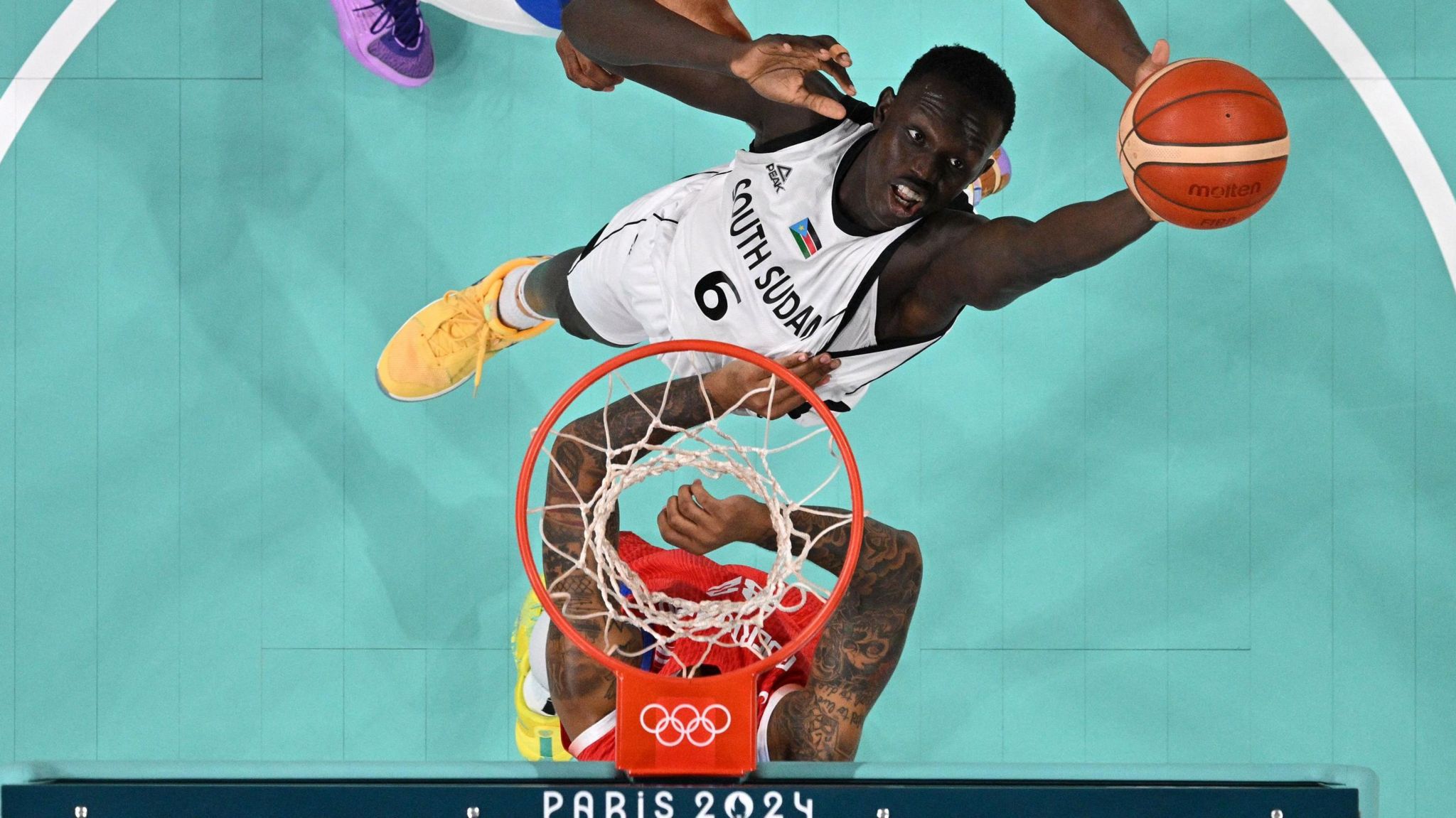 Khaman Maluach attempts to tip a basketball into a basket during a game at the Paris 2024 Olympics