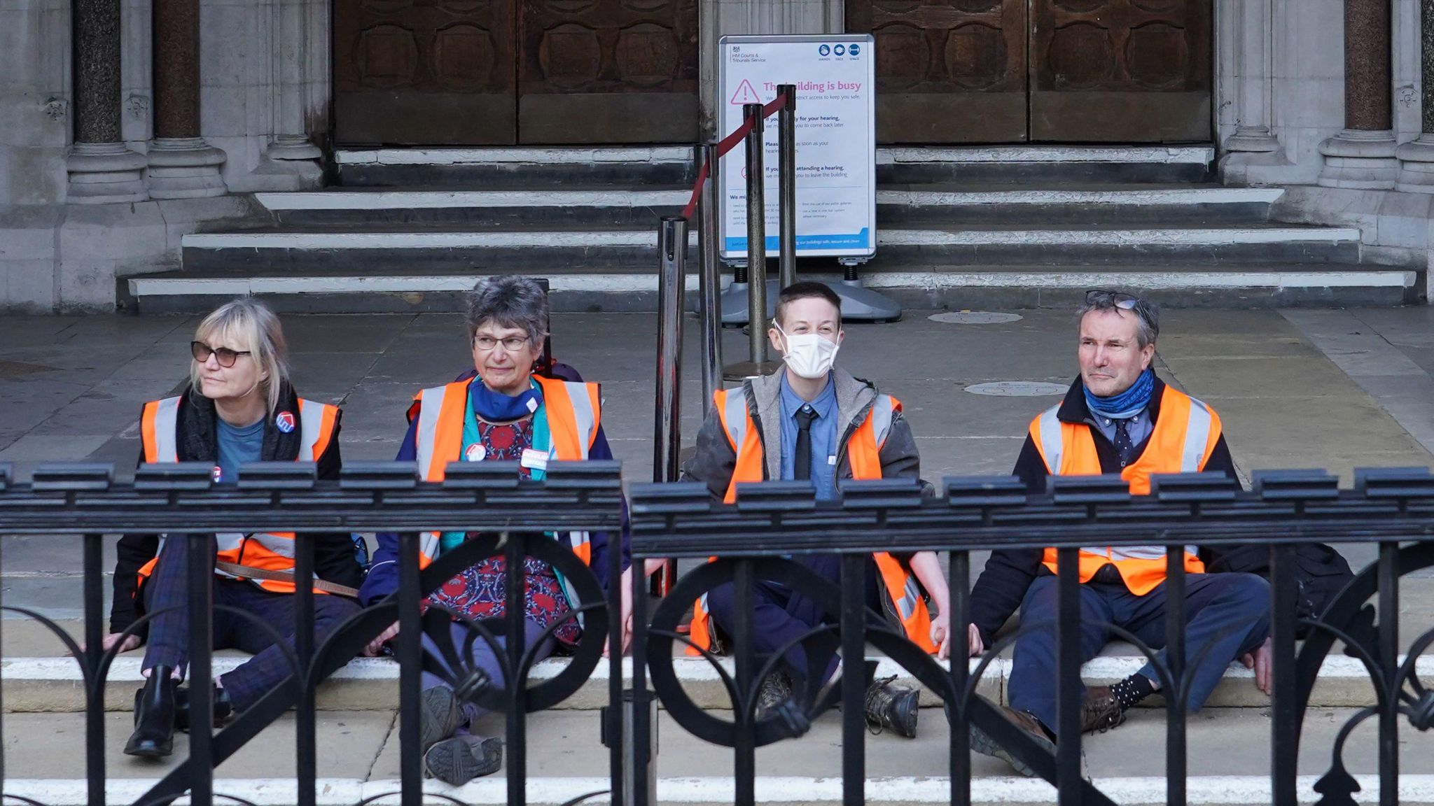 (Left-right) Theresa Norton, Dr Diana Warner, El Litten, and Steve Pritchard, sitting outside the Royal Courts of Justice in London. They are members of Insulate Britain and they glued themselves to the ground outside the court.