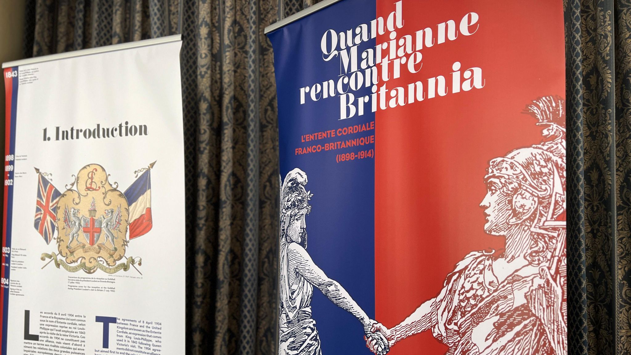French banners with French and British flags and two historical characters shaking hands