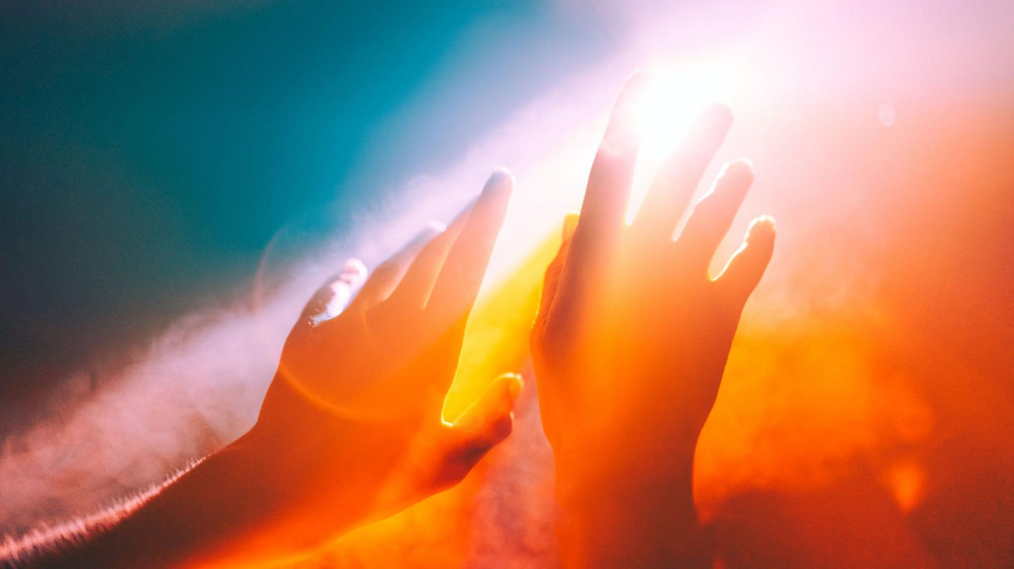 Photo of two hands held up to the sunshine