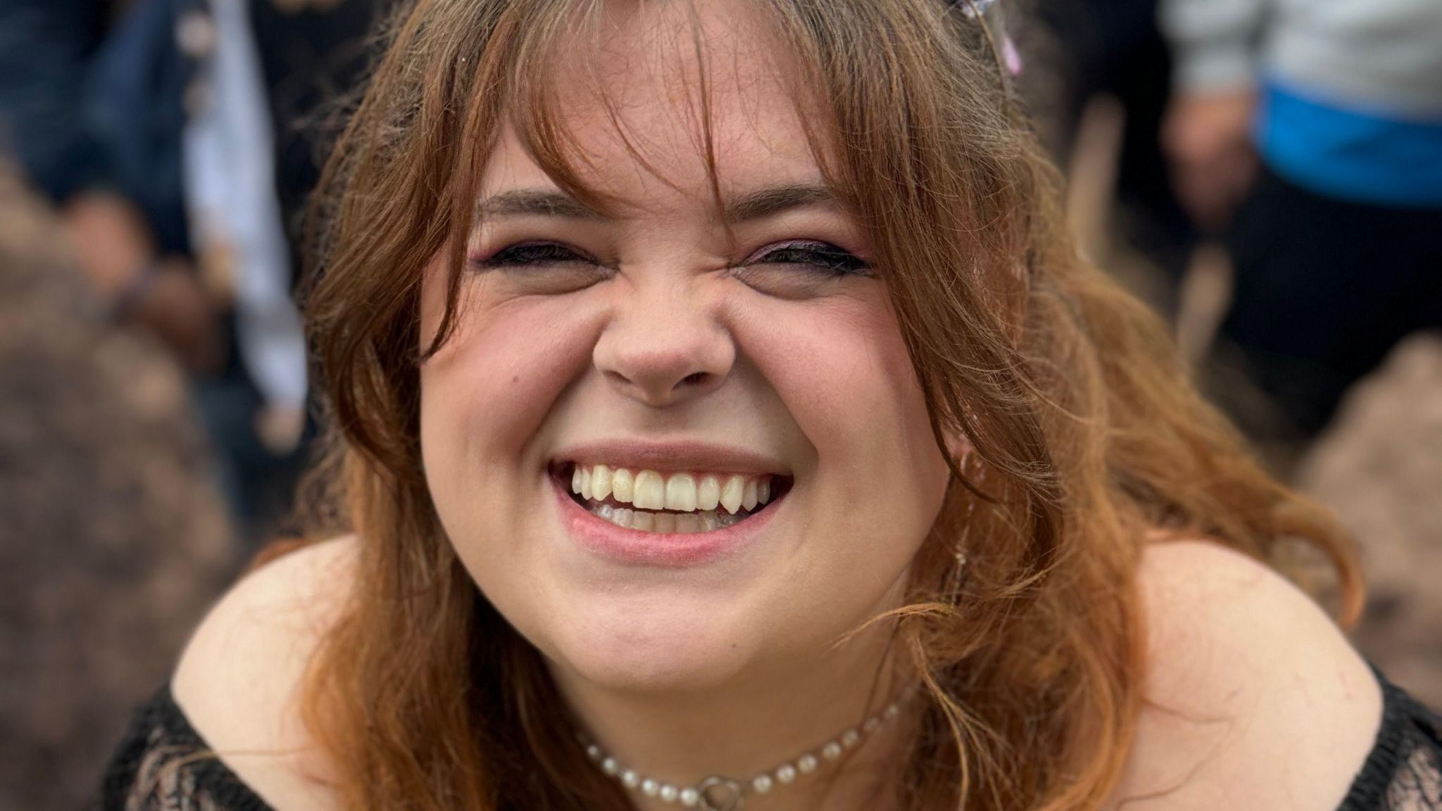 A young woman smiles into the camera