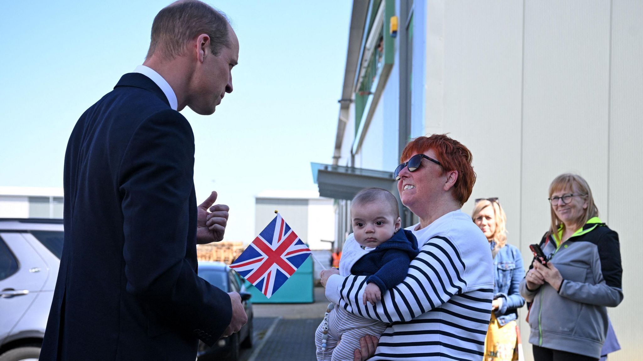 Prince William speaking to a woman and her baby grandson