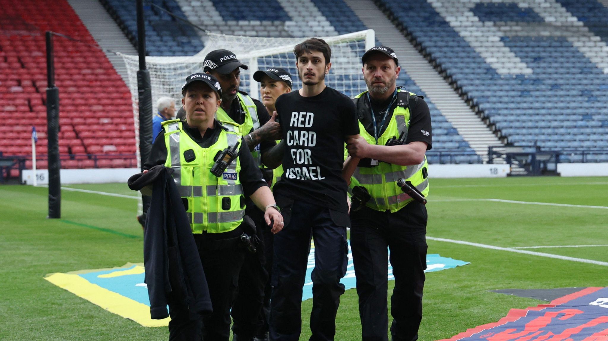 The protester being removed from the pitch by police