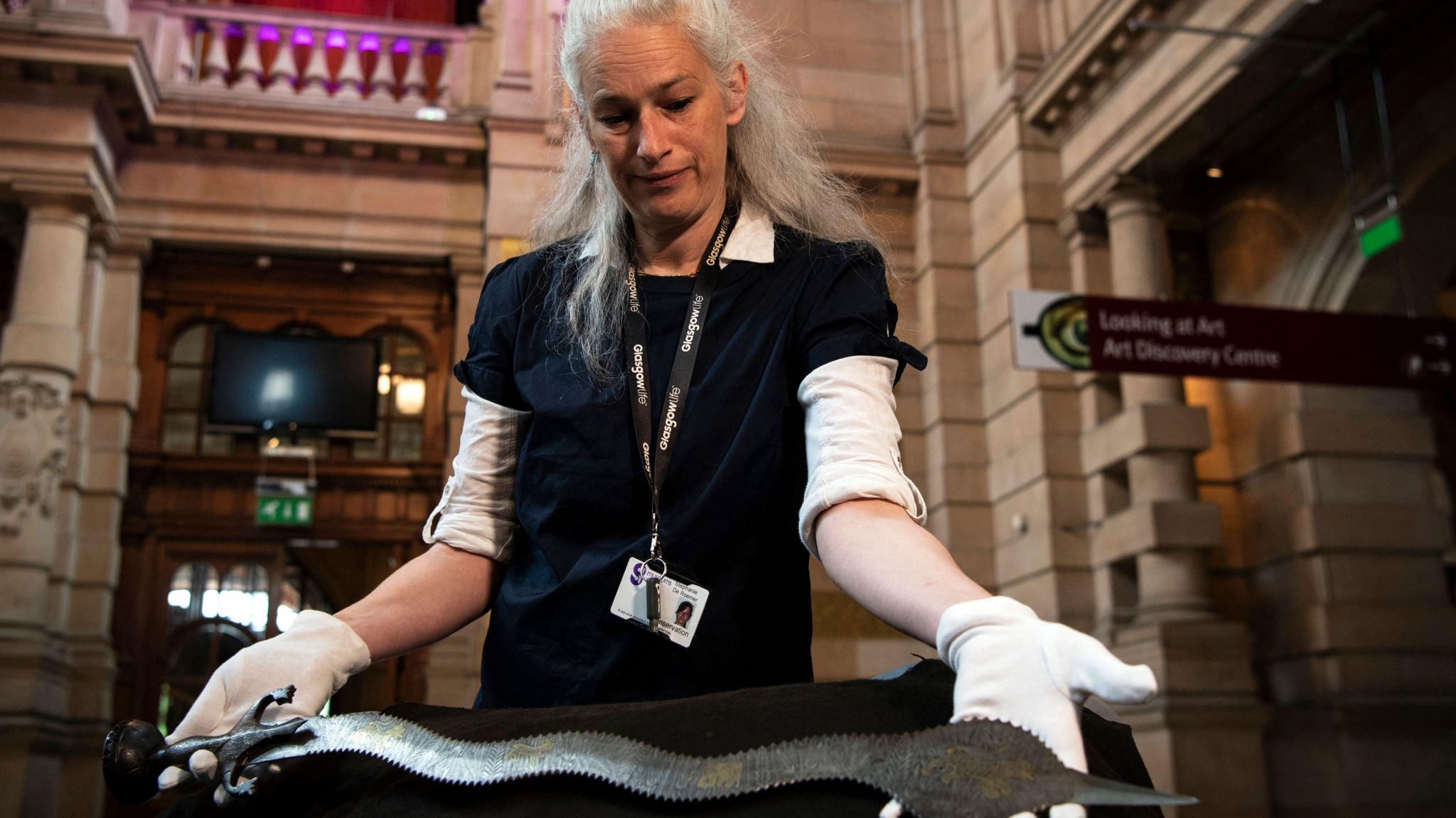 Museum conservator Stephanie De Roemer holds a ceremonial Indo-Persian sword during a transfer of ownership ceremony at Kelvingrove Art Gallery and Museum