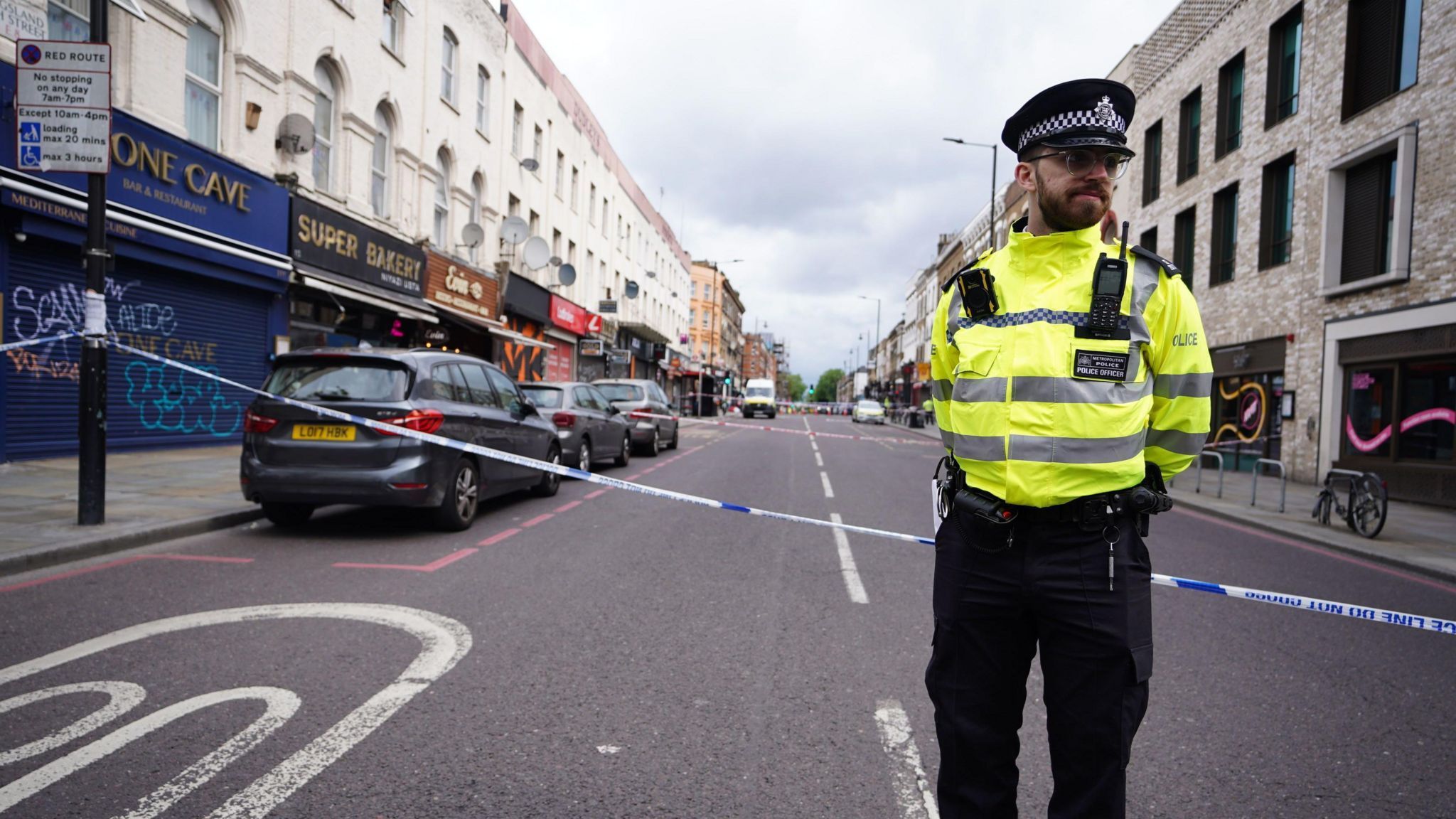 A photo of a police officer next to a police cordon