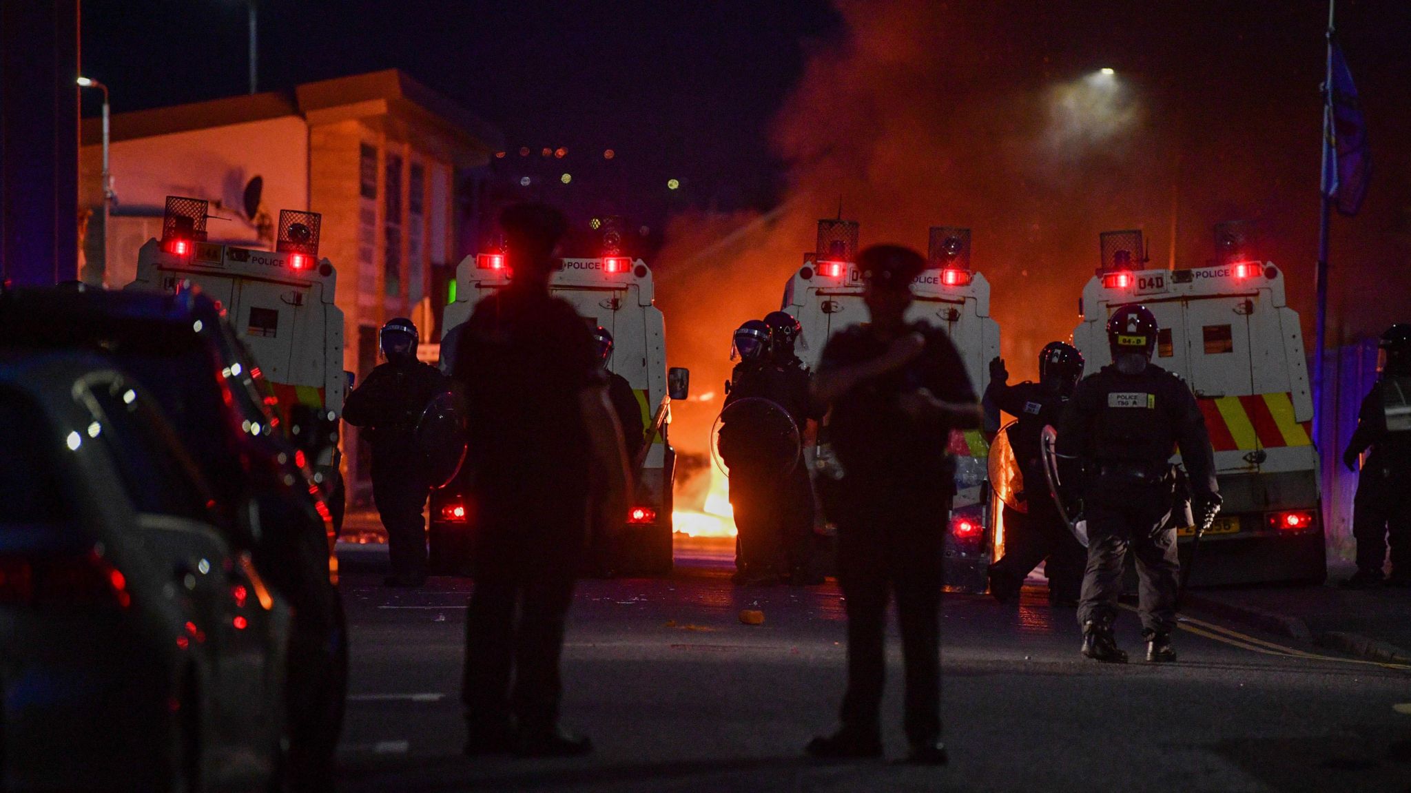 Riot police on Donegall Road with fire in background