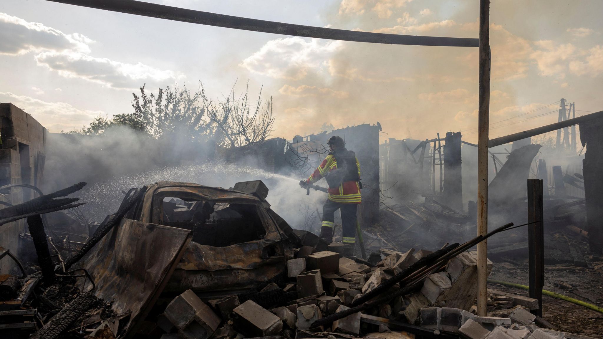 An emergency worker extinguishes a fire that destroyed a private house after a Russian strike on a residential area in Pokrovsk