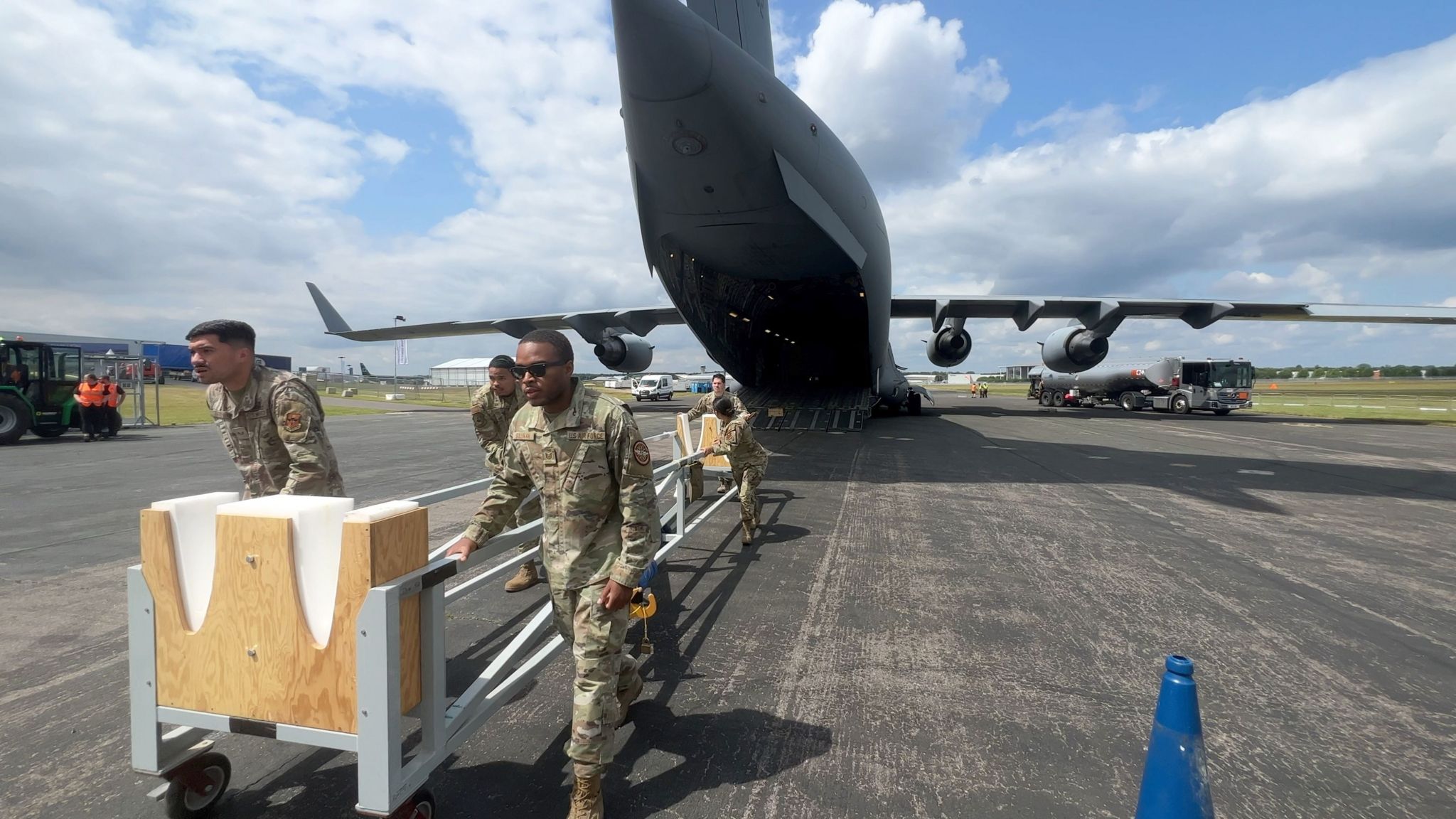 US personel unload equipment from a C17 transport plane.