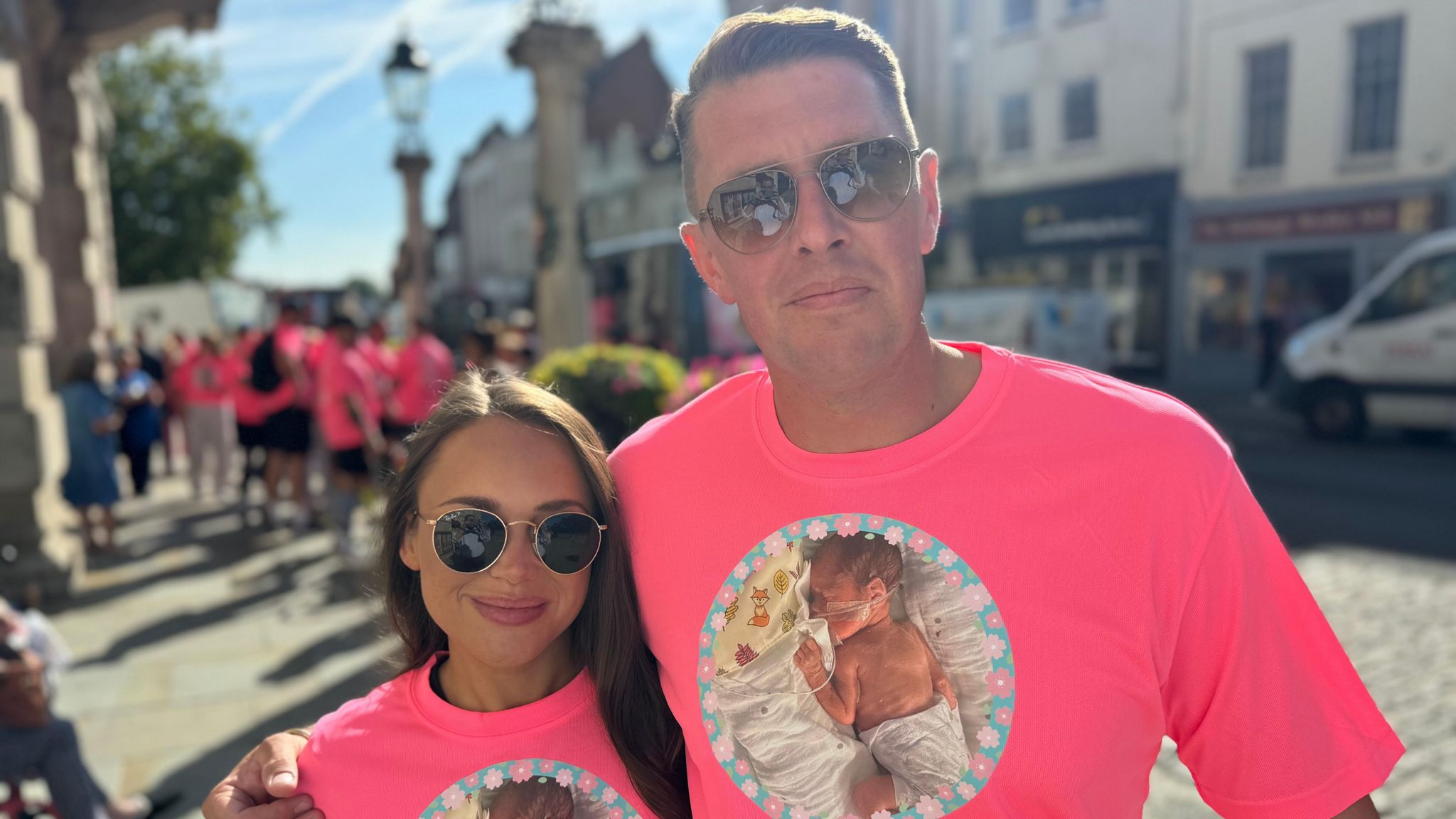 Lottie Mears and Charlie Lawrence wearing pink T-shirts with a picture of Celine on them outside Colchester Town Hall