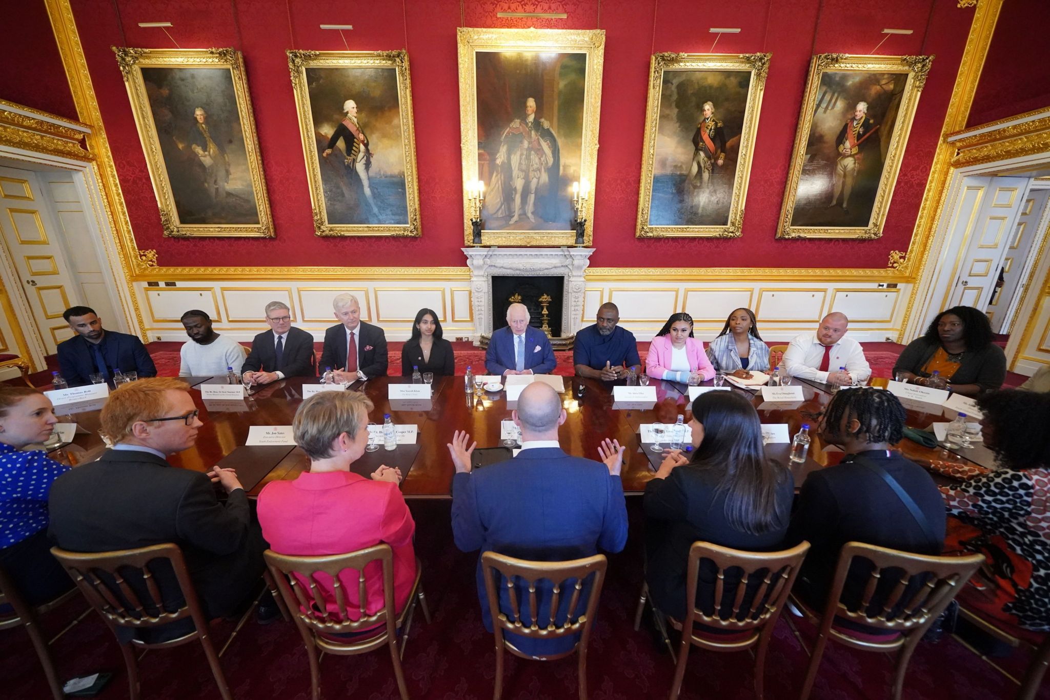 The King, PM, senior politicians and actor Idris Elba at a table meeting young people from the King's Trust