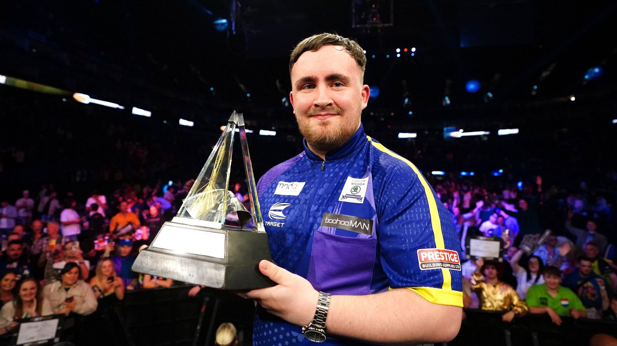 Luke Littler holding the Premier League Darts trophy