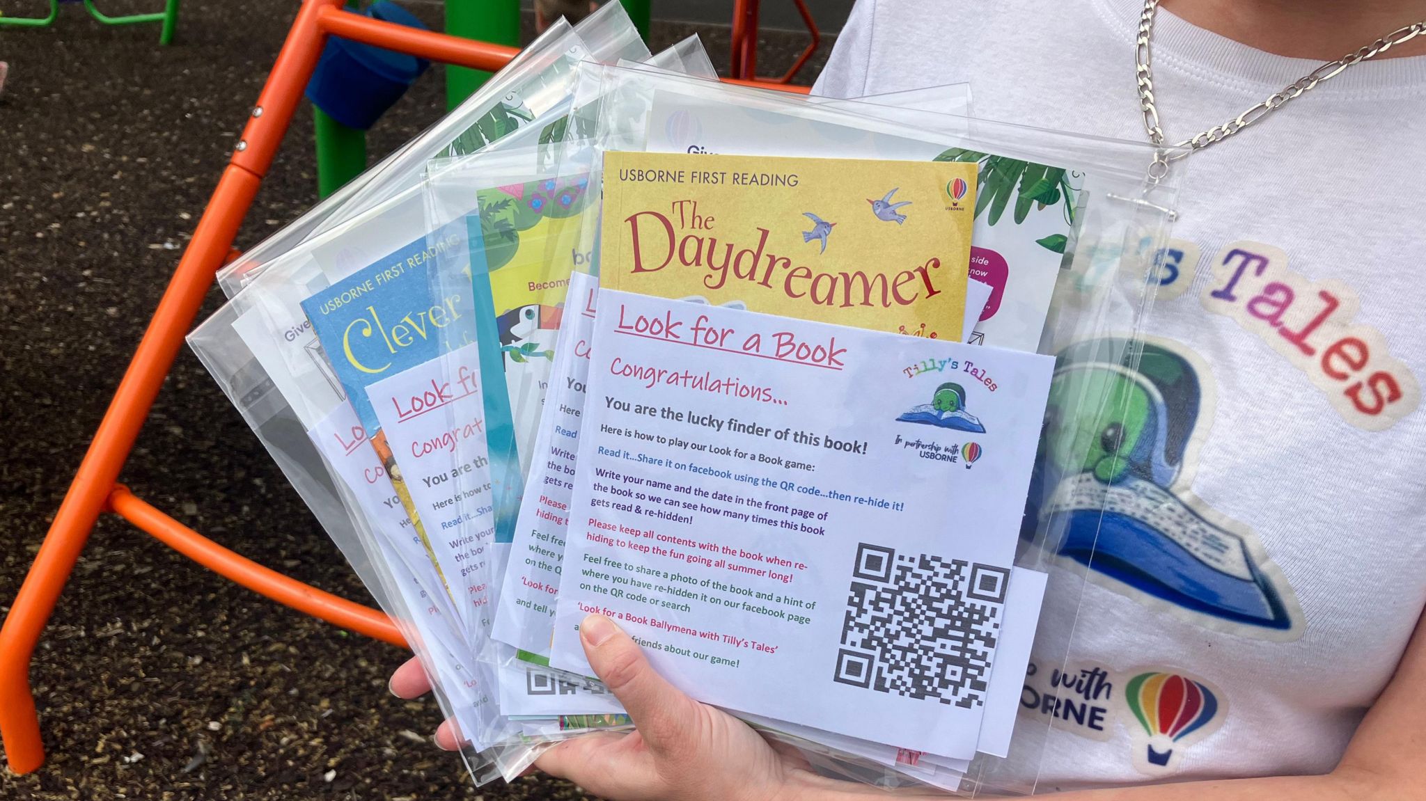 A stack of books in plastic wrapping which will be hidden for kids to find