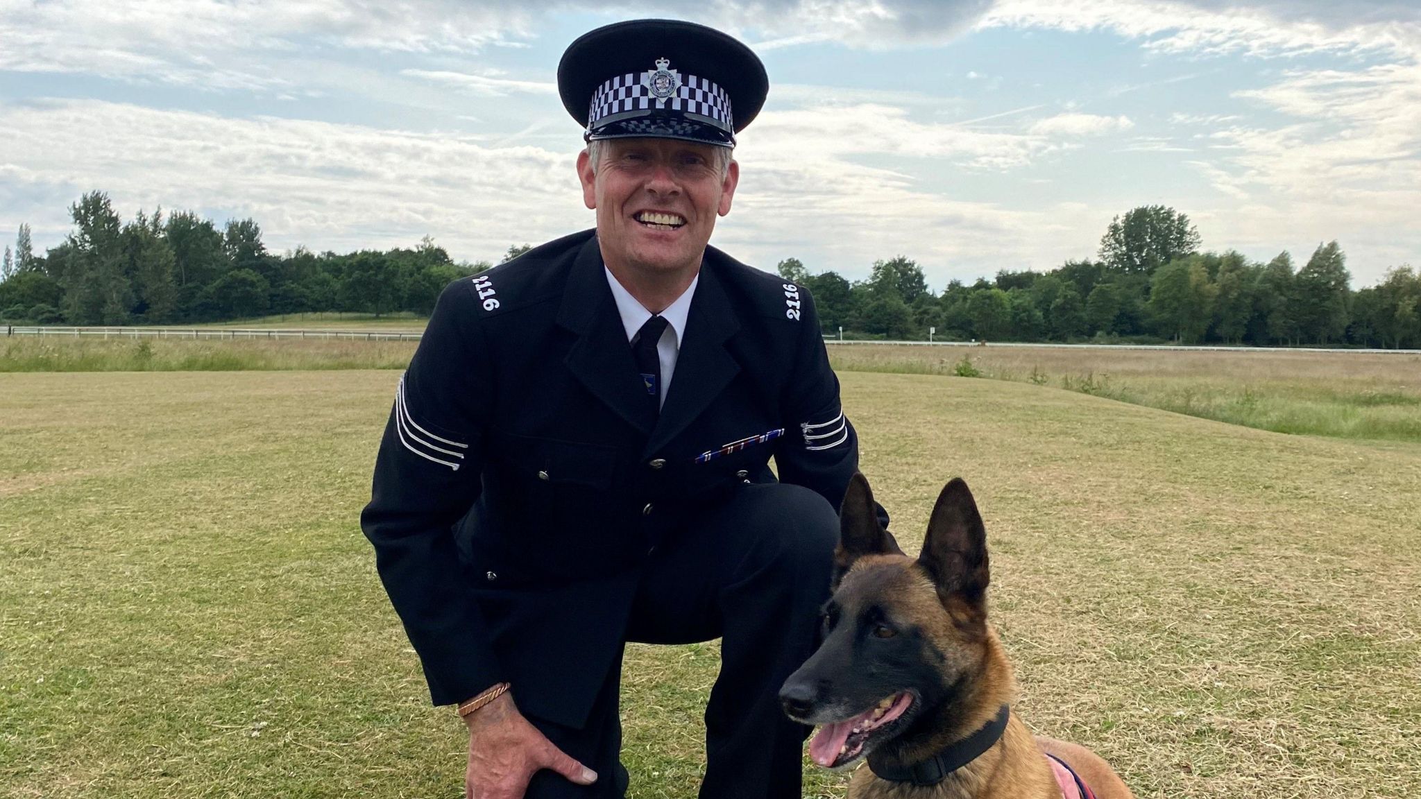 Nick and police dog Eva together, he is smiling at the camera and wearing his full uniform