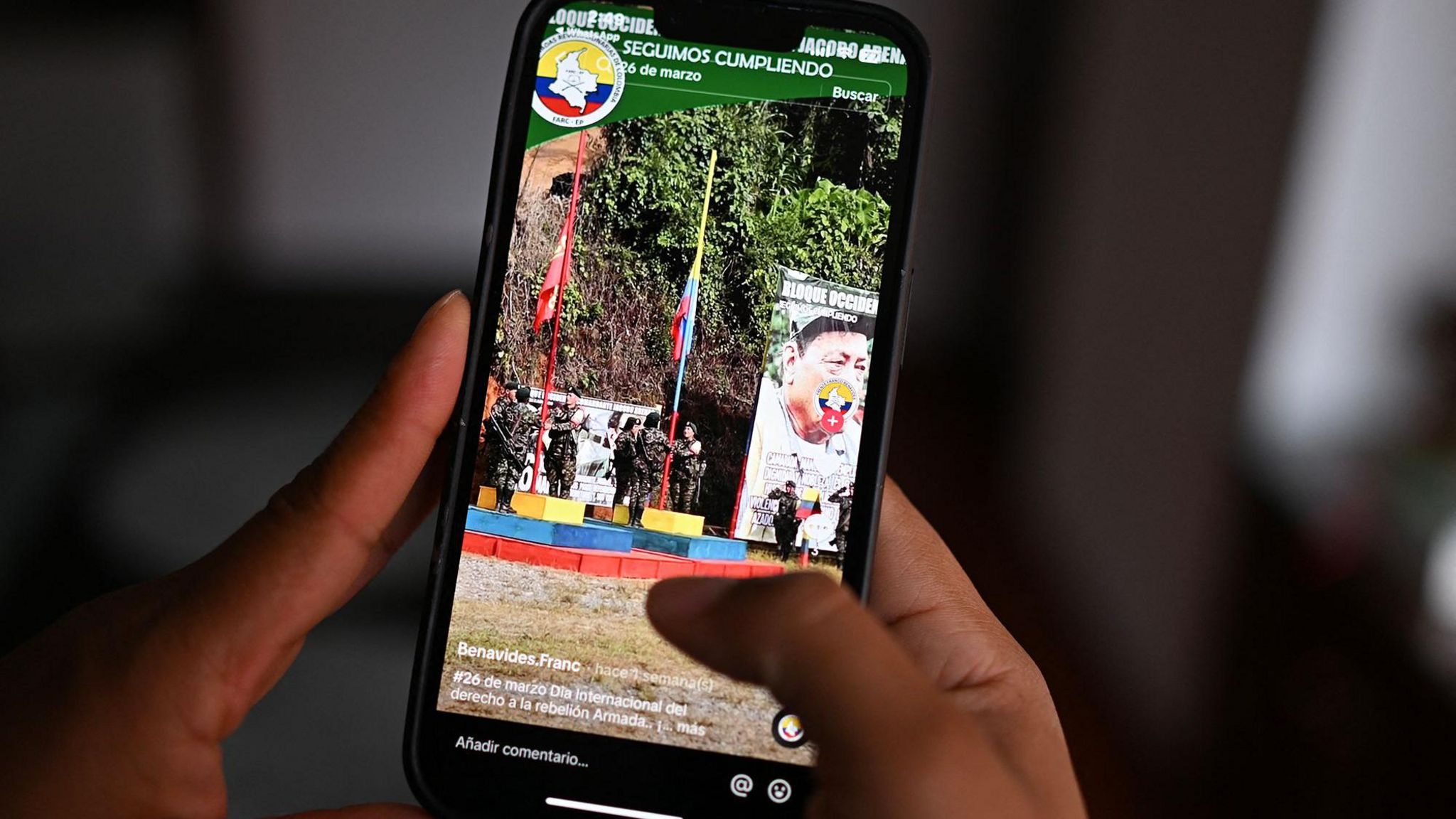 An image of a hand holding a mobile phone showing a TikTok account that promotes one of the dissident armed groups in Colombia.