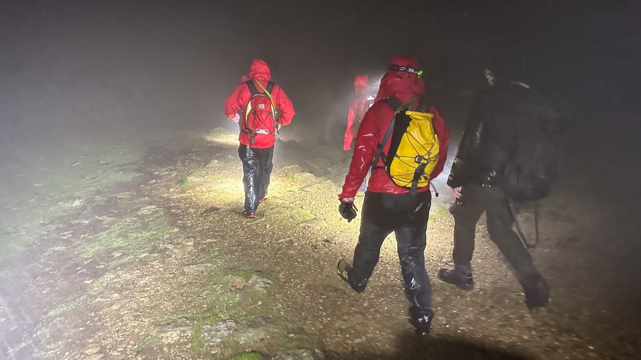 Four mountain rescue volunteers walking to Helvellyn in the torrential rain