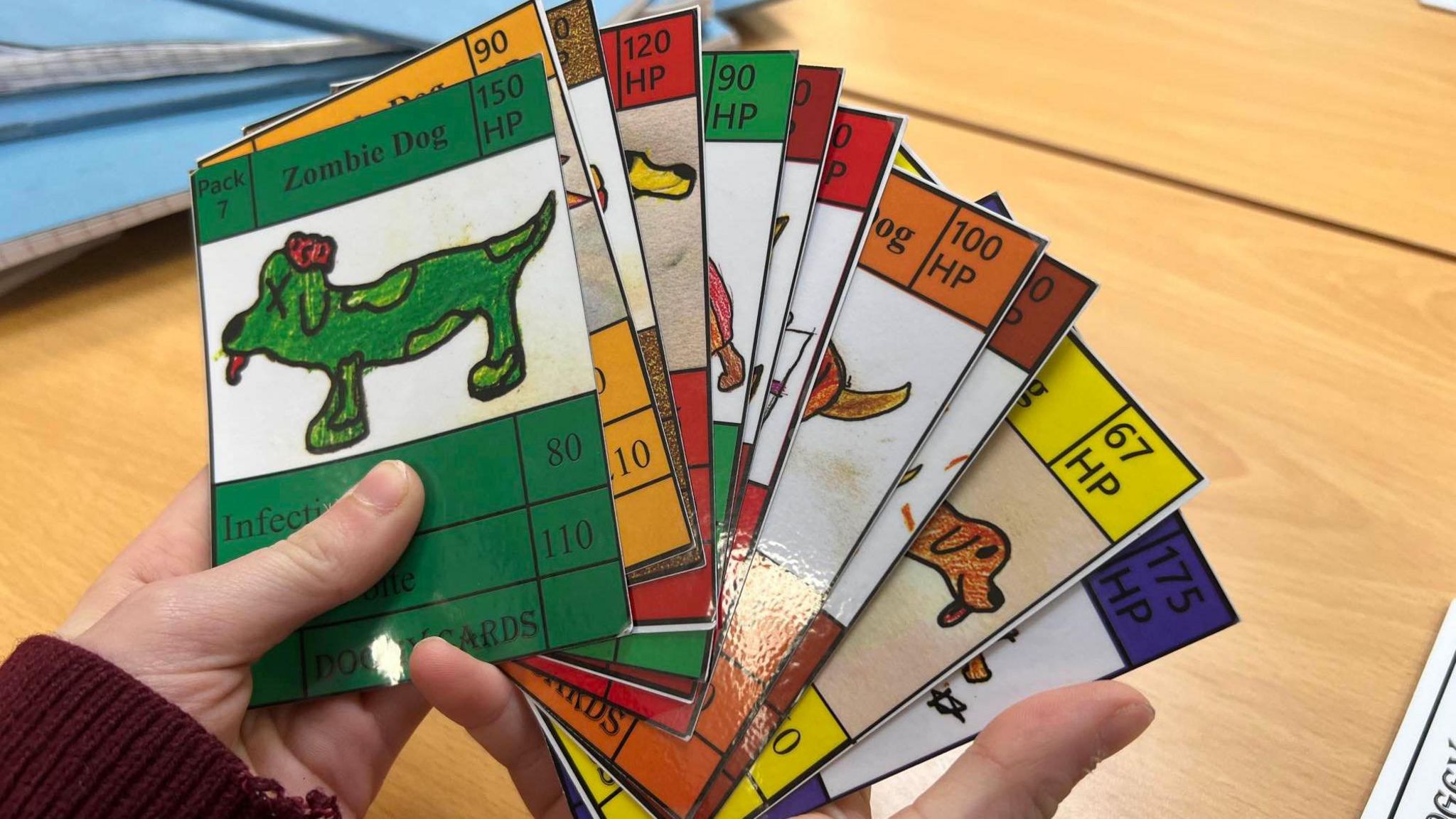 A close up of the cards, one of which has the title 'Zombie Dog' and shows a green, ill looking animal