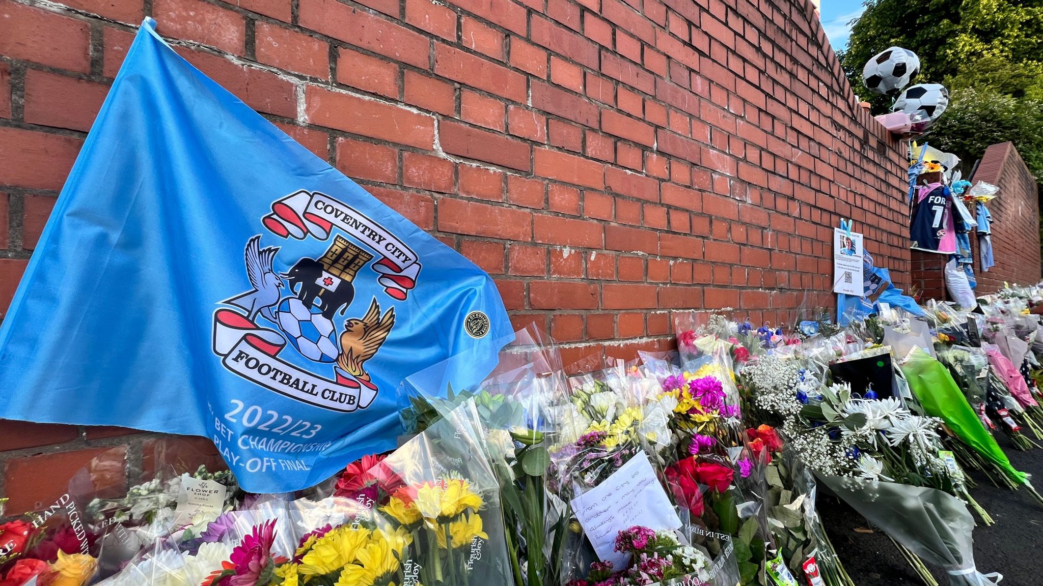 A Coventry City flag among the floral tributes