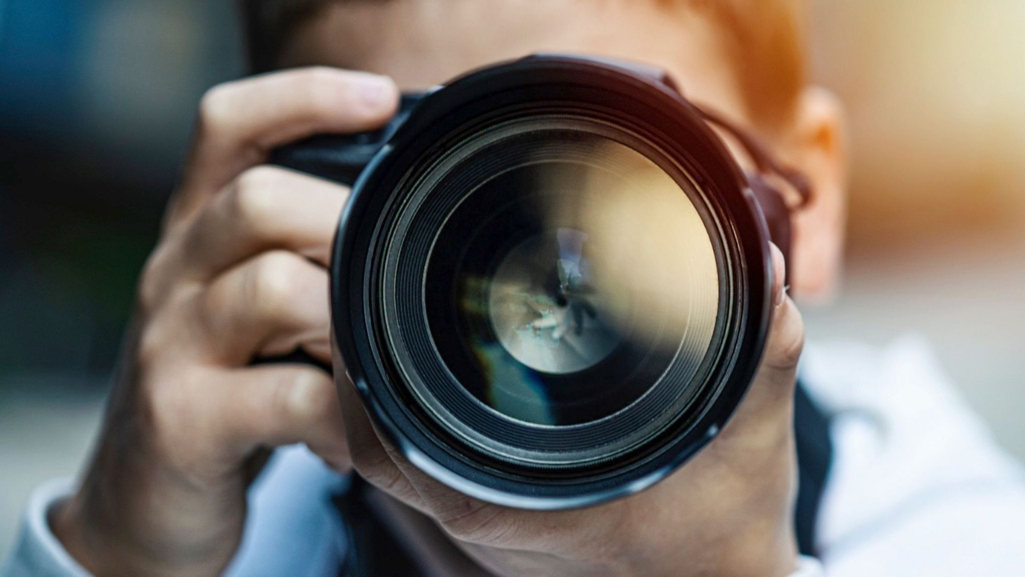 A man with a camera taking a photo.